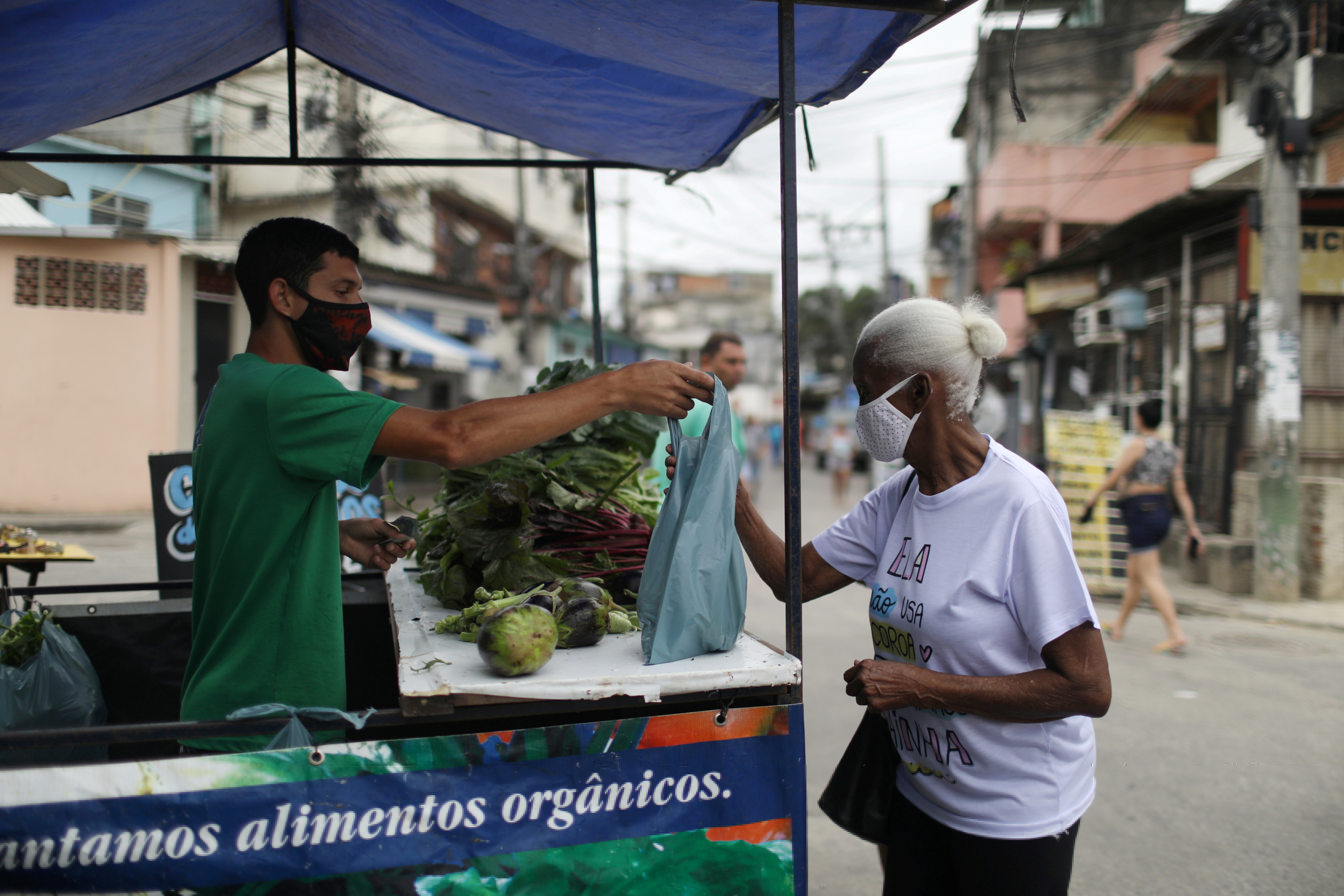 A woman buys vegetables from the Horta de Manguinhos (Manguinhos vegetable garden), the biggest urban garden in Latin America, part of the project 
