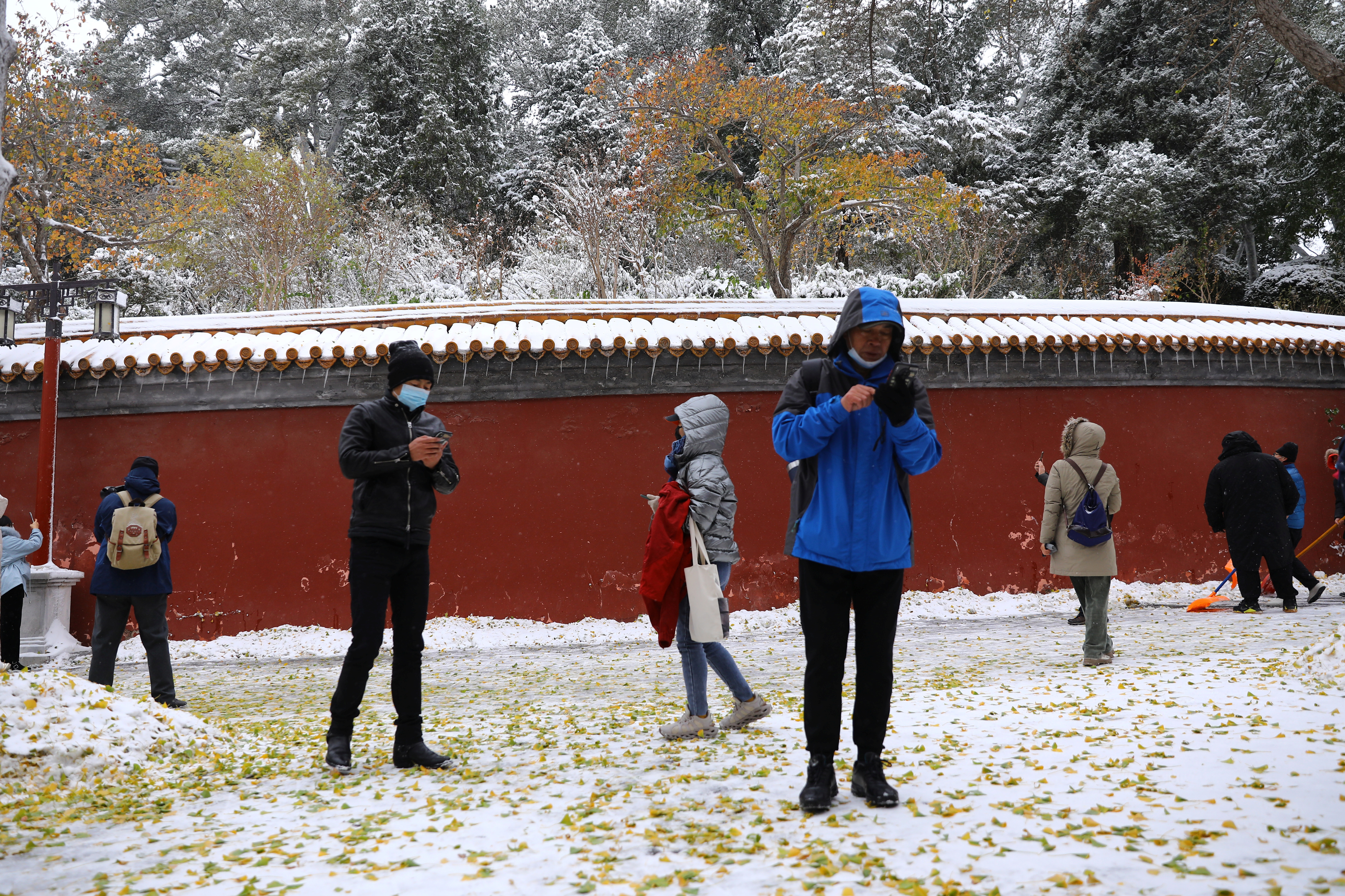 Tourists enjoy snowfall at Jingshan Park, in Beijing