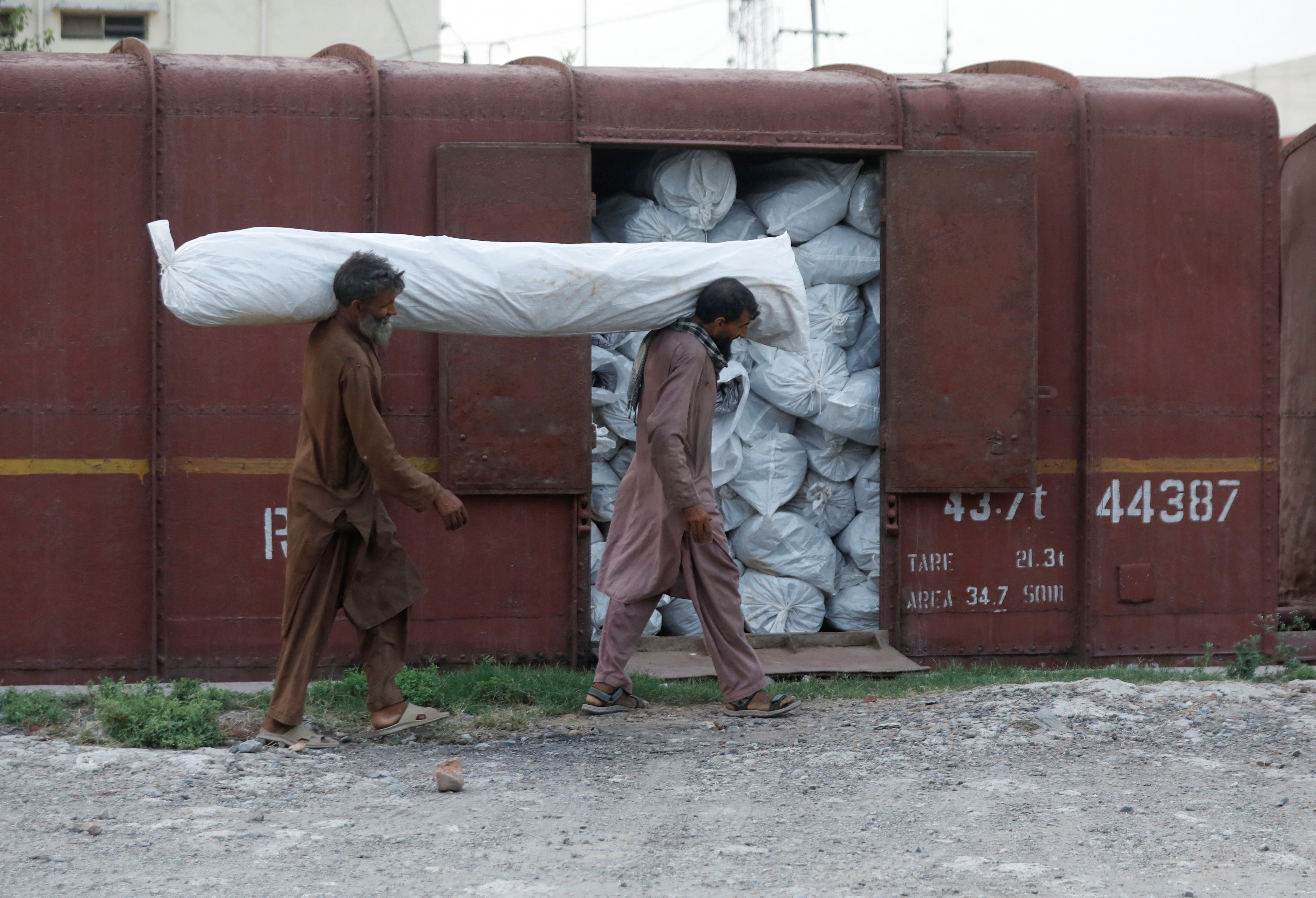 Workers load tents for the flood victims in Balochistan, in Peshawar