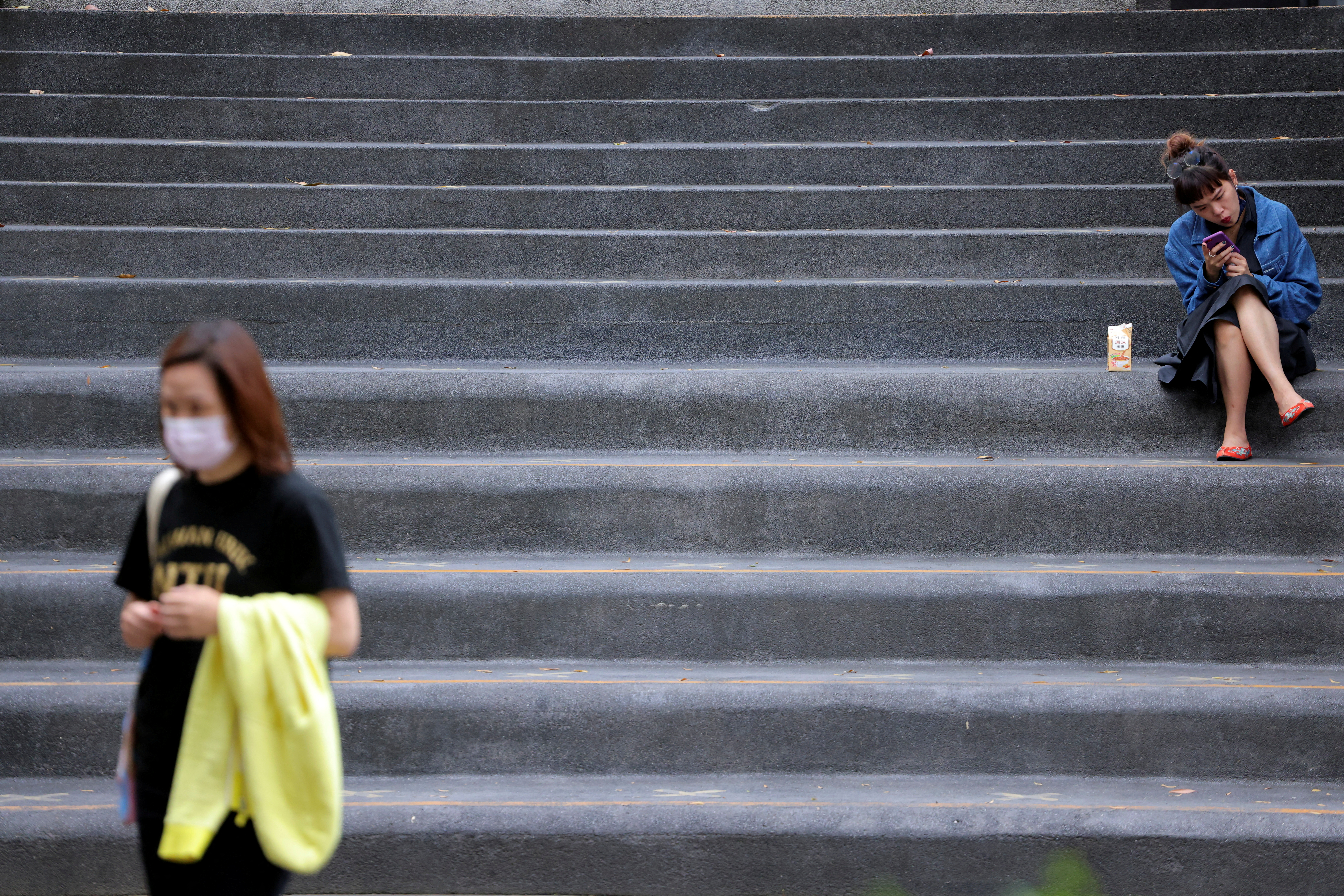 Woman sits on a staircase in Taipei