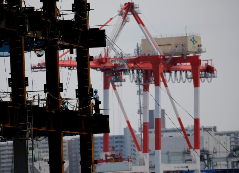 A man works in a construction site at an industrial port in Tokyo