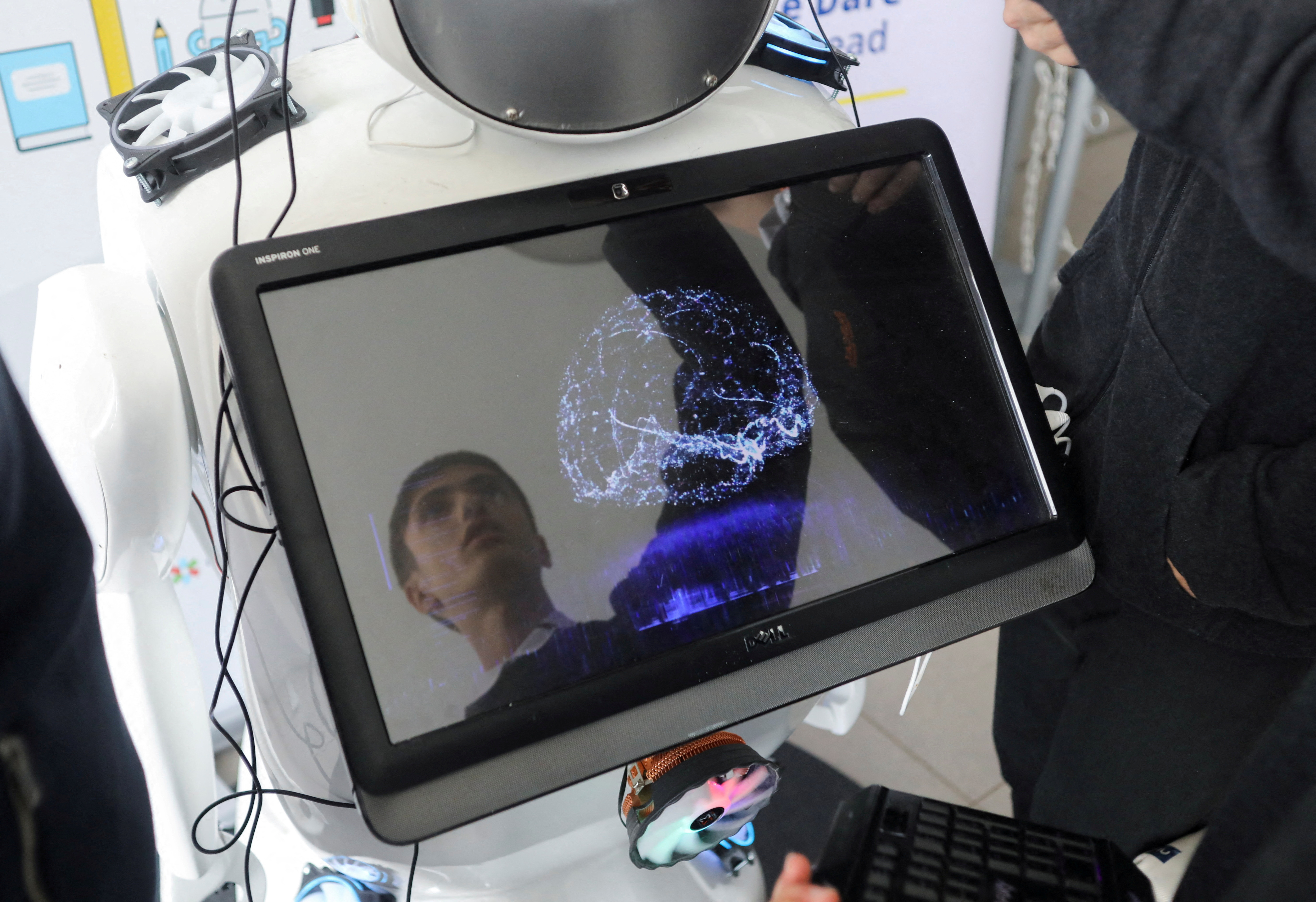 High school student Richard Erkhov is reflected on a screen of "Alnstein", a robot powered with ChatGPT, in Pascal school in Nicosia
