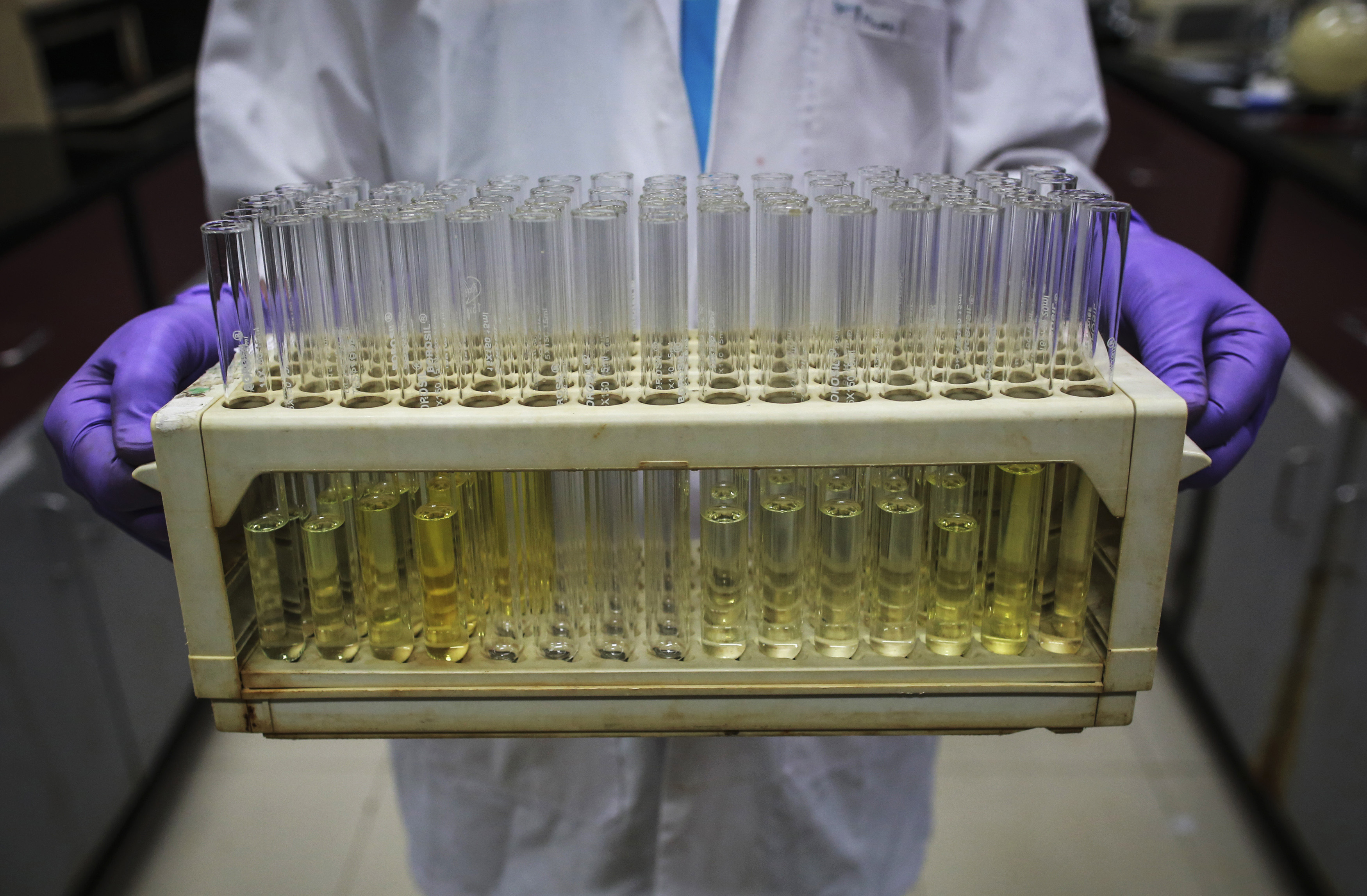 An employee carries test tubes inside a laboratory at Piramal's Research Centre in Mumbai
