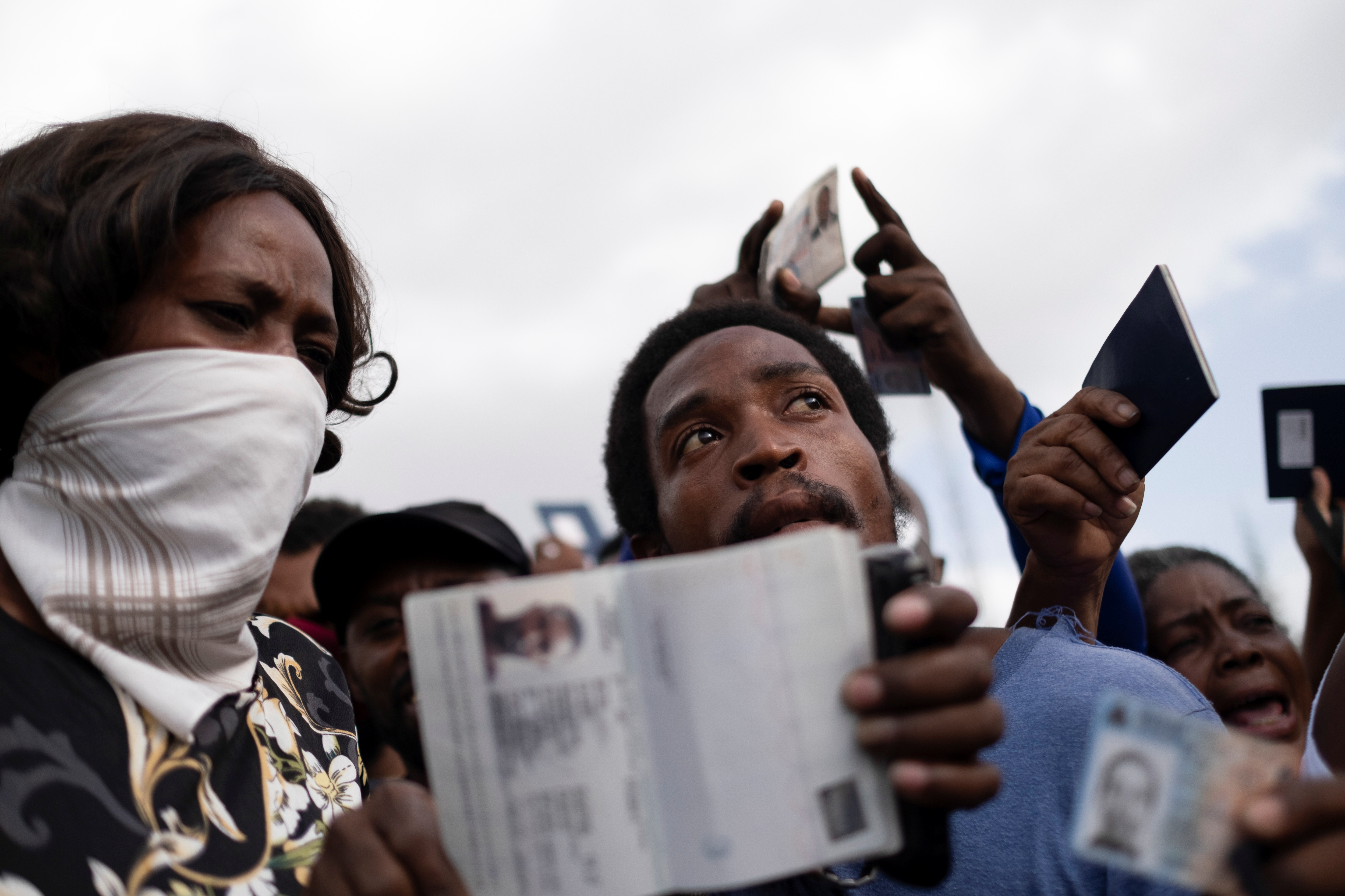 Los haitianos que solicitan asilo muestran sus pasaportes haitianos frente a la embajada de Estados Unidos, luego del asesinato del presidente Jovenel Moise, en Puerto Príncipe, Haití, el 9 de julio de 2021. REUTERS / Ricardo Arduengo