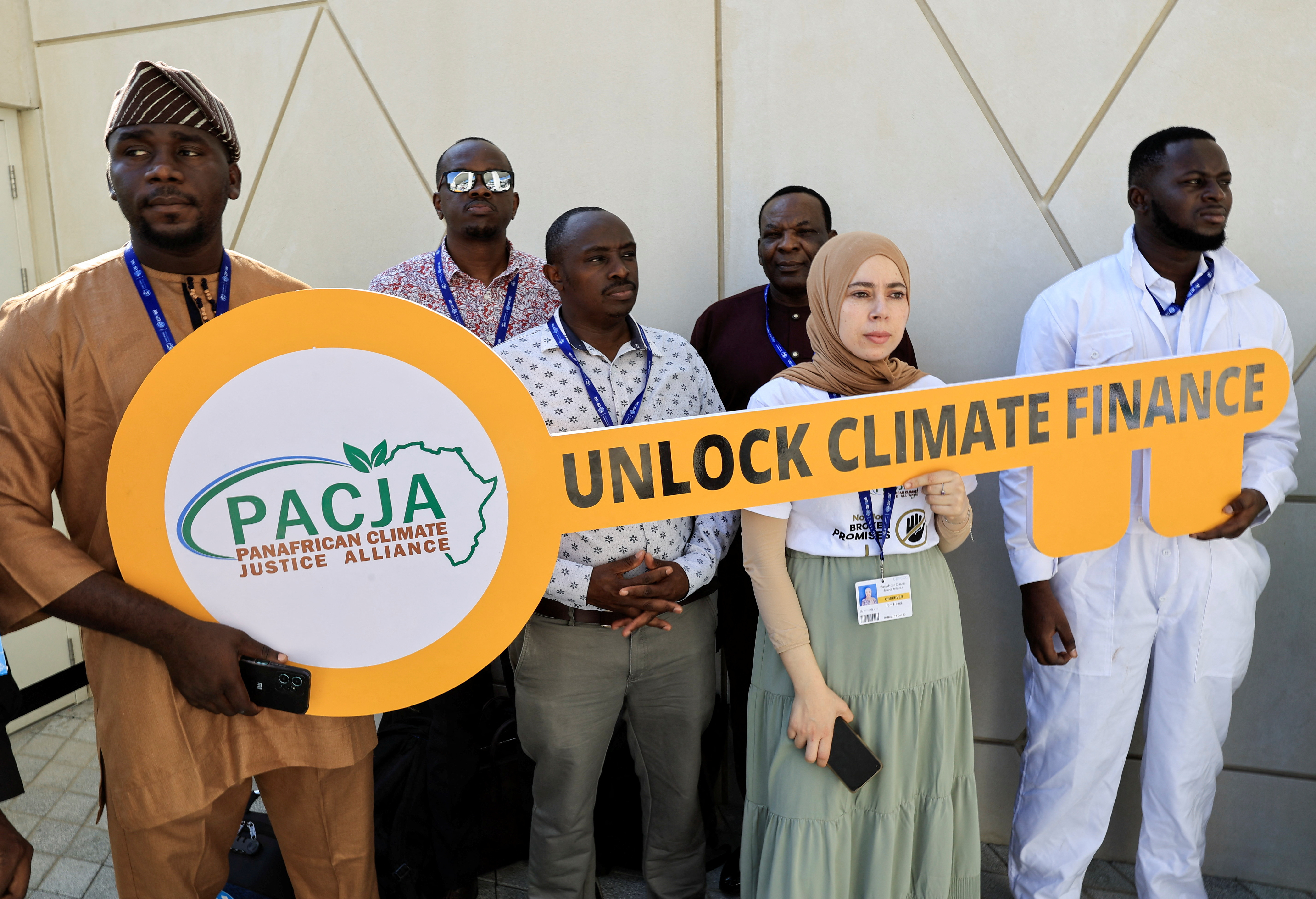 Ativistas seguram uma placa que diz "Desbloqueie o financiamento climático" durante um protesto na Conferência das Nações Unidas sobre Mudanças Climáticas COP28 em Dubai
