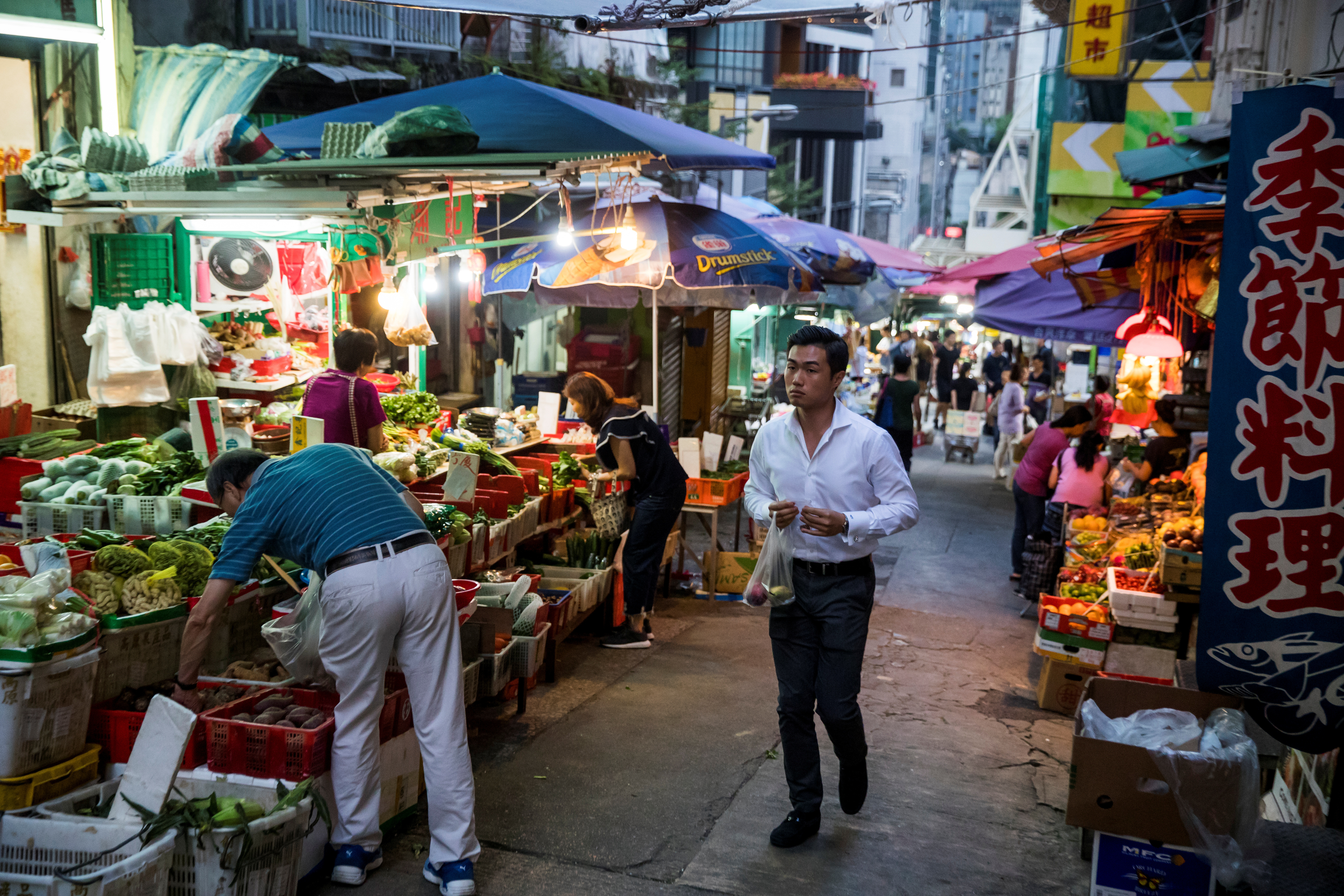A man walks through a food market in an alley in Sheung Wan in Hong Kong