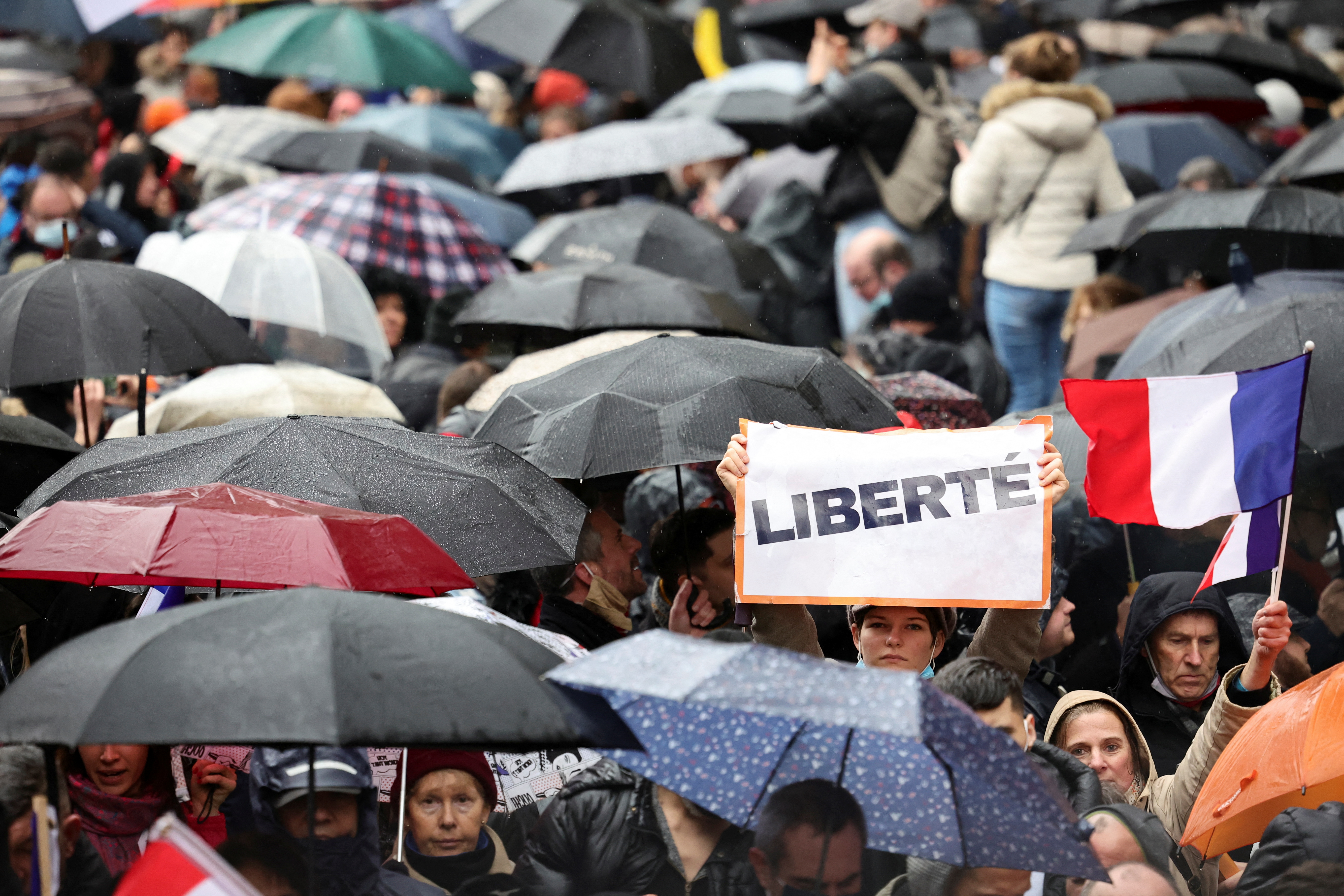 A person holds a sign that reads "Freedom" as people attend a demonstration to protest against a bill that would transform France's current coronavirus disease (COVID-19) health pass into a ''vaccine pass'', in Paris, France, January 8, 2022. REUTERS/Sarah Meyssonnier