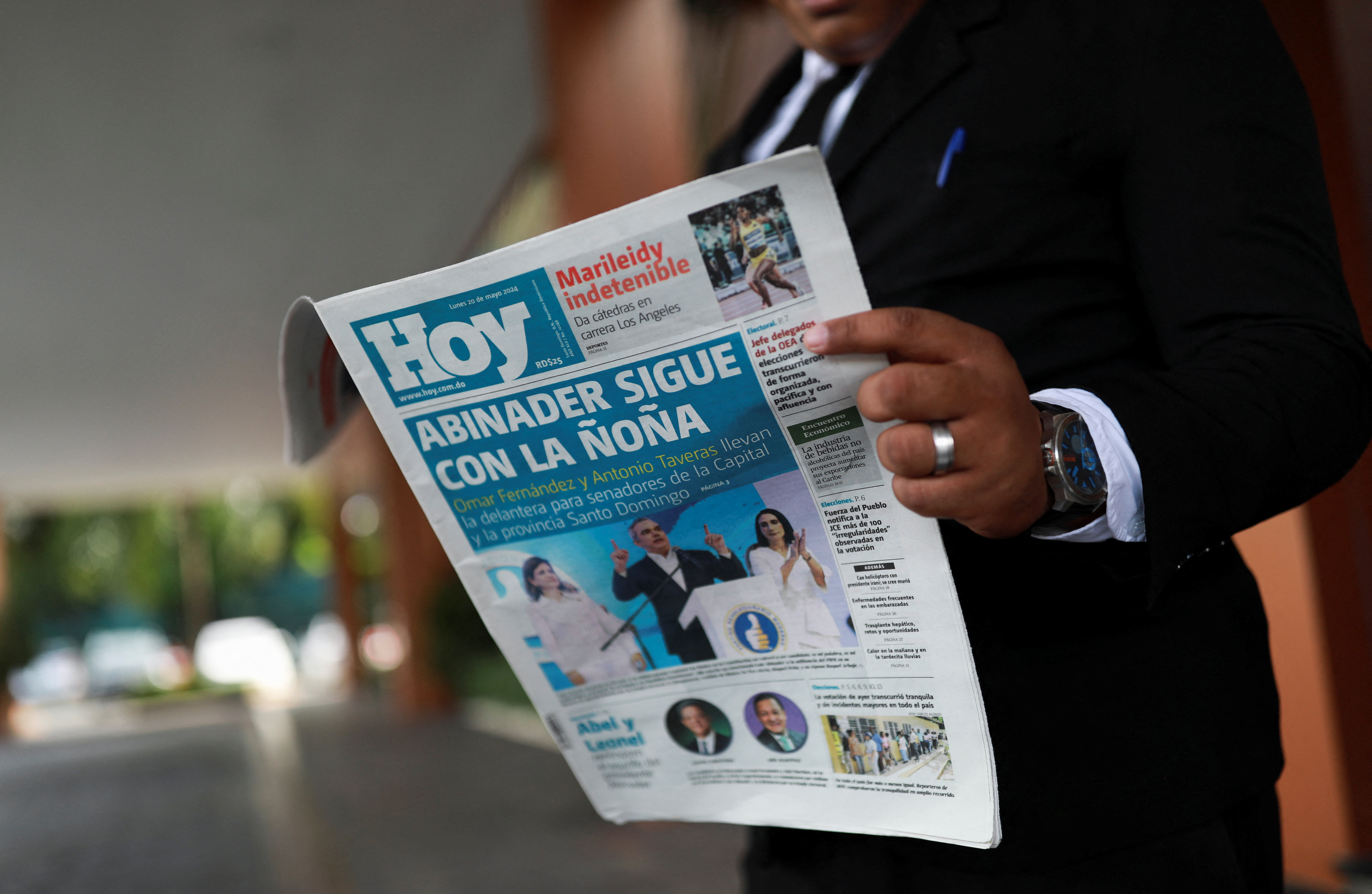 A man reads a newspaper a day after the general election in Santo Domingo