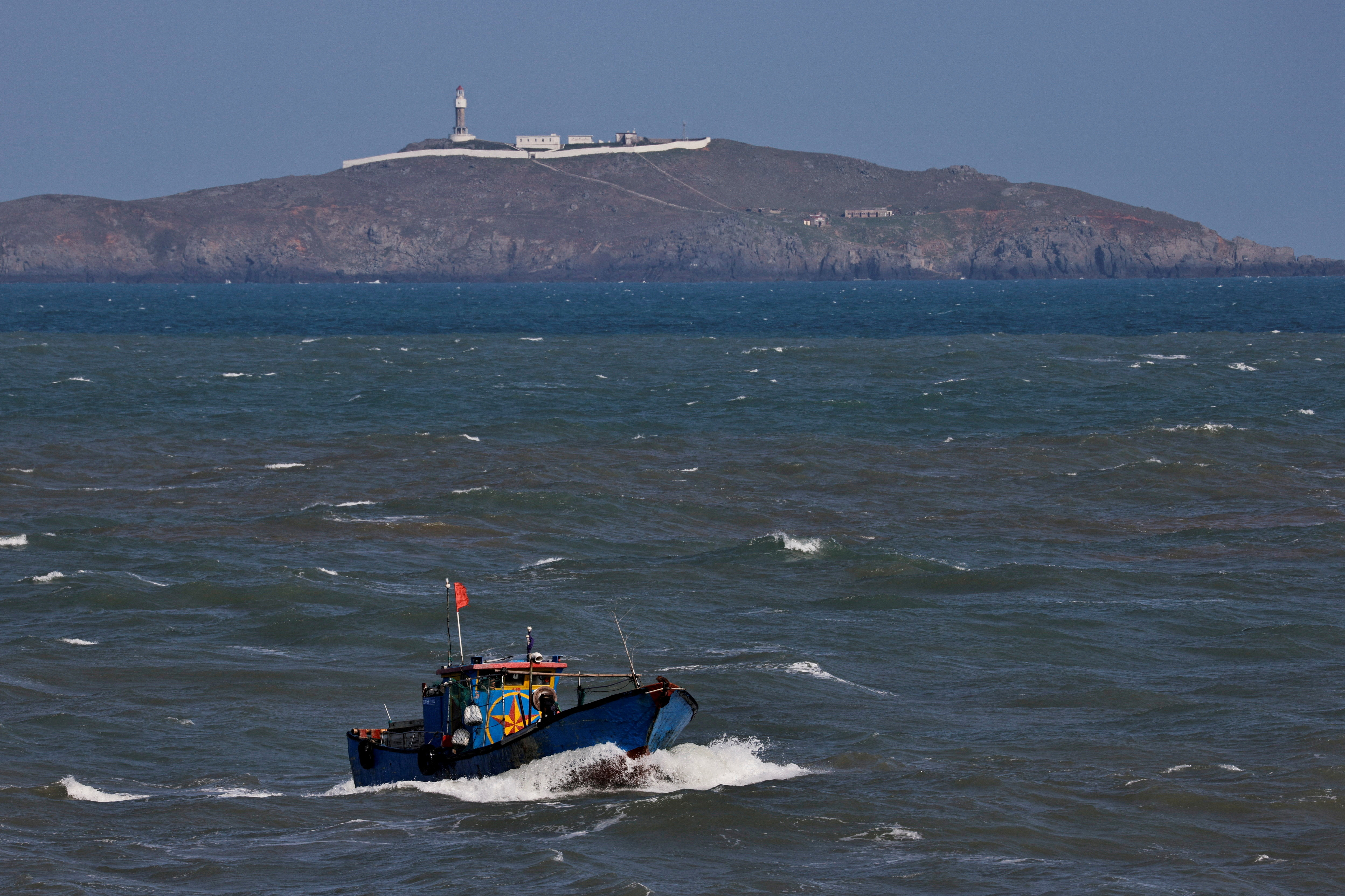 A Chinese fishing boat sails across the Taiwan Strait near Niushan Island, off Pingtan Island