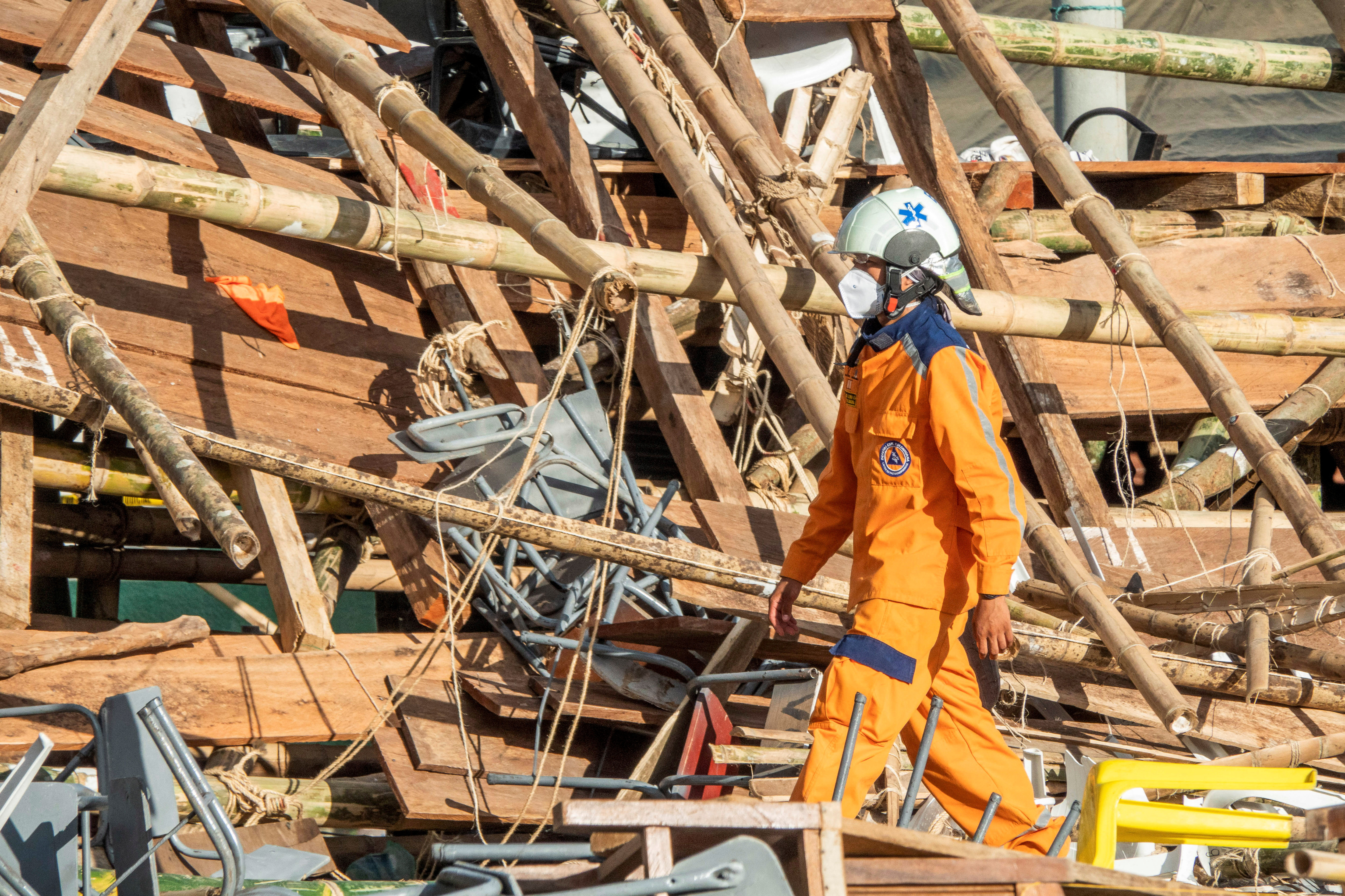 A Colombian Civil Defense worker walks amidst the rubble of some stands that collapsed in a bullring during the celebrations of the San Pedro festivities, in El Espinal