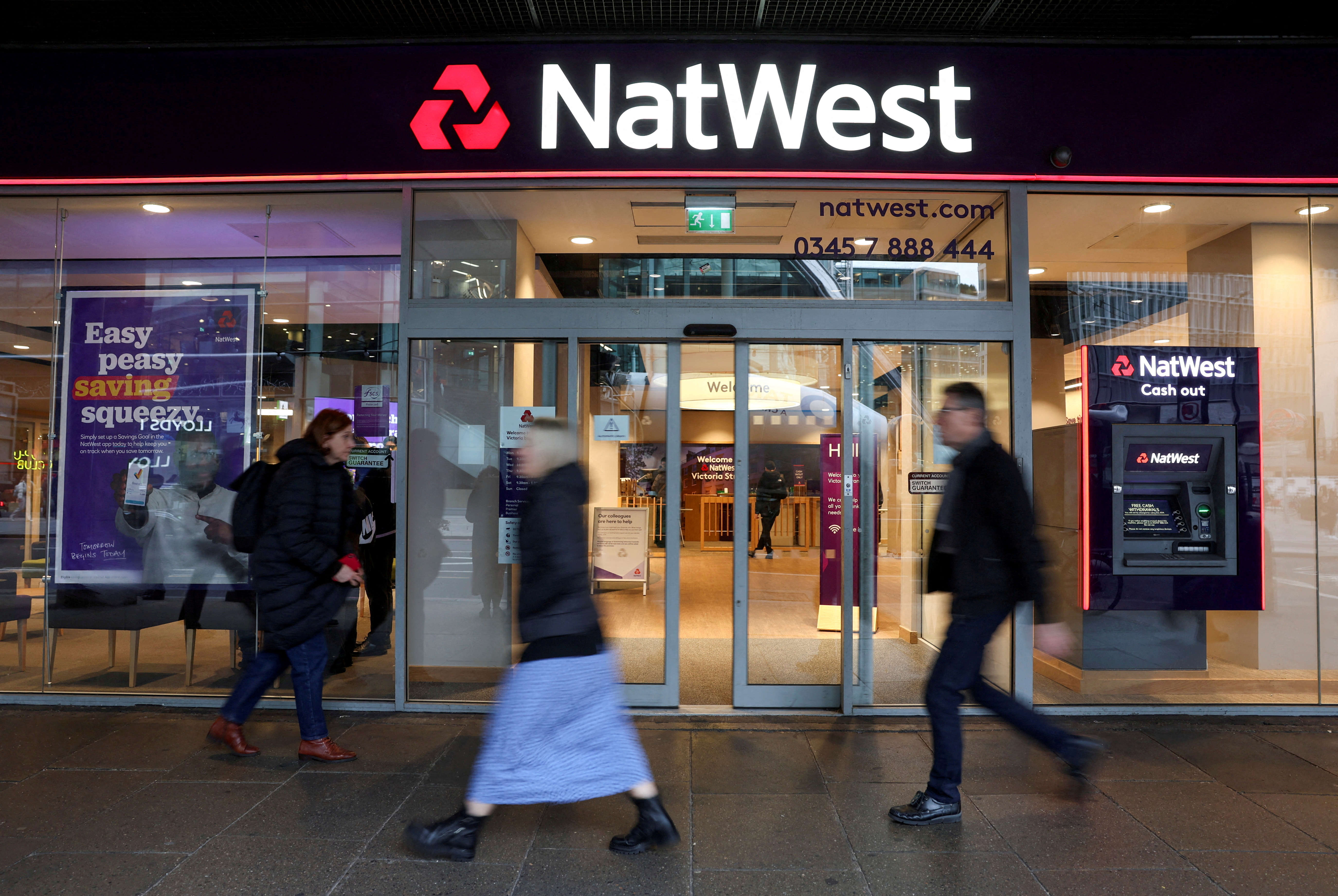People walk past a Natwest Bank branch in central London