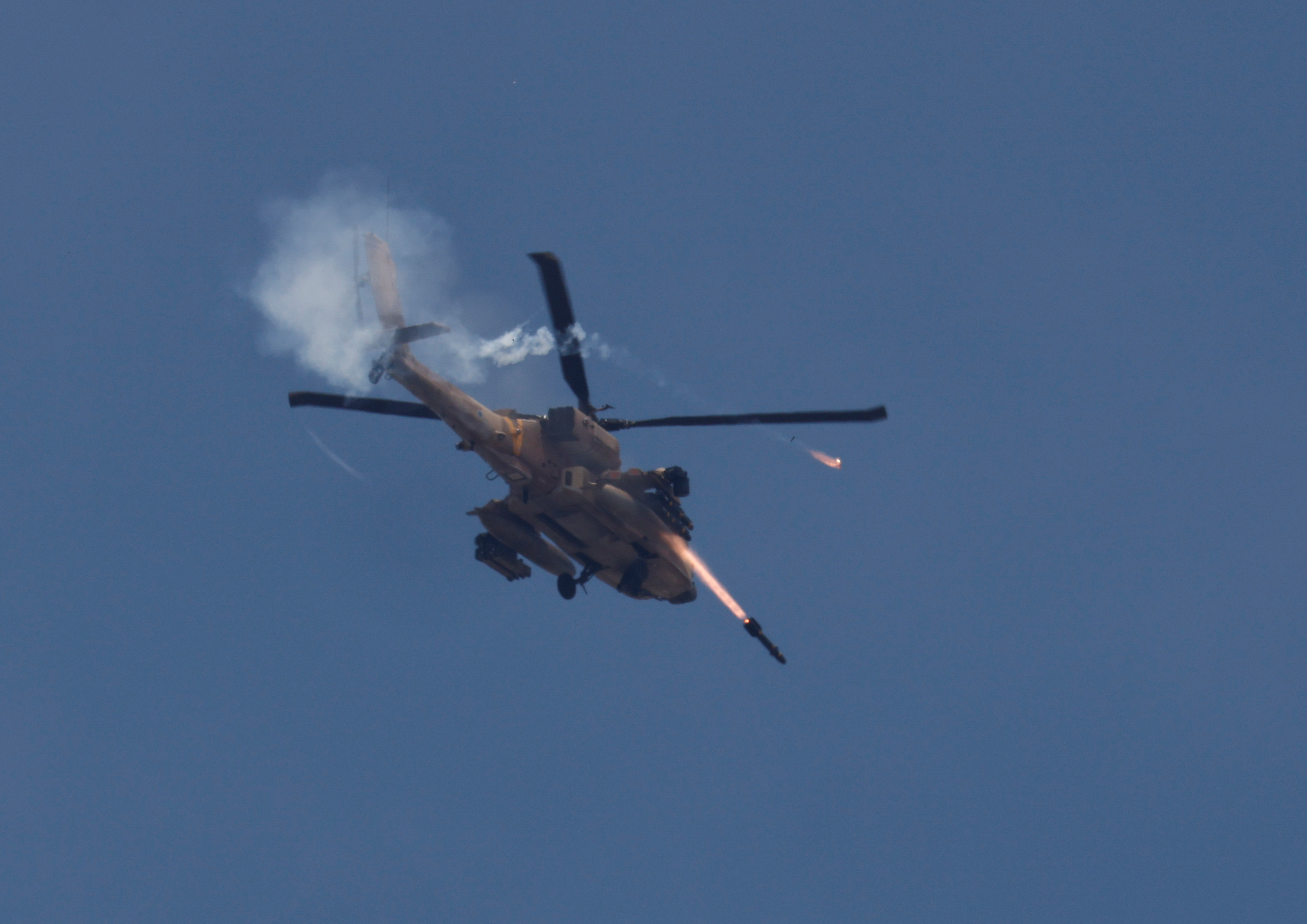 An Israeli military Apache helicopter fires missiles towards Gaza as seen from southern Israel
