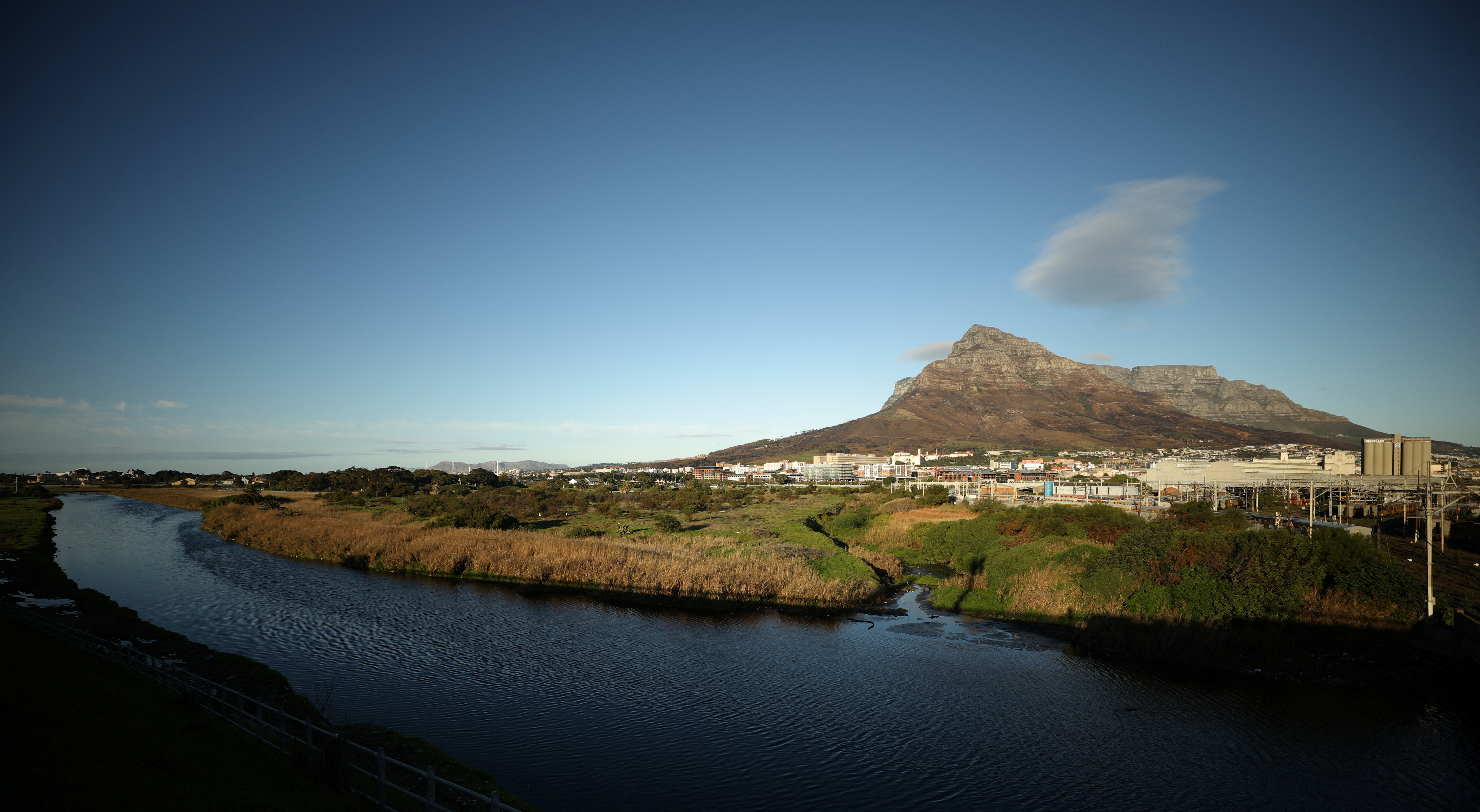 Contested land earmarked for a development which includes a new Africa headquarters for U.S. retail giant Amazon is seen alongside the Black River in Cape Town