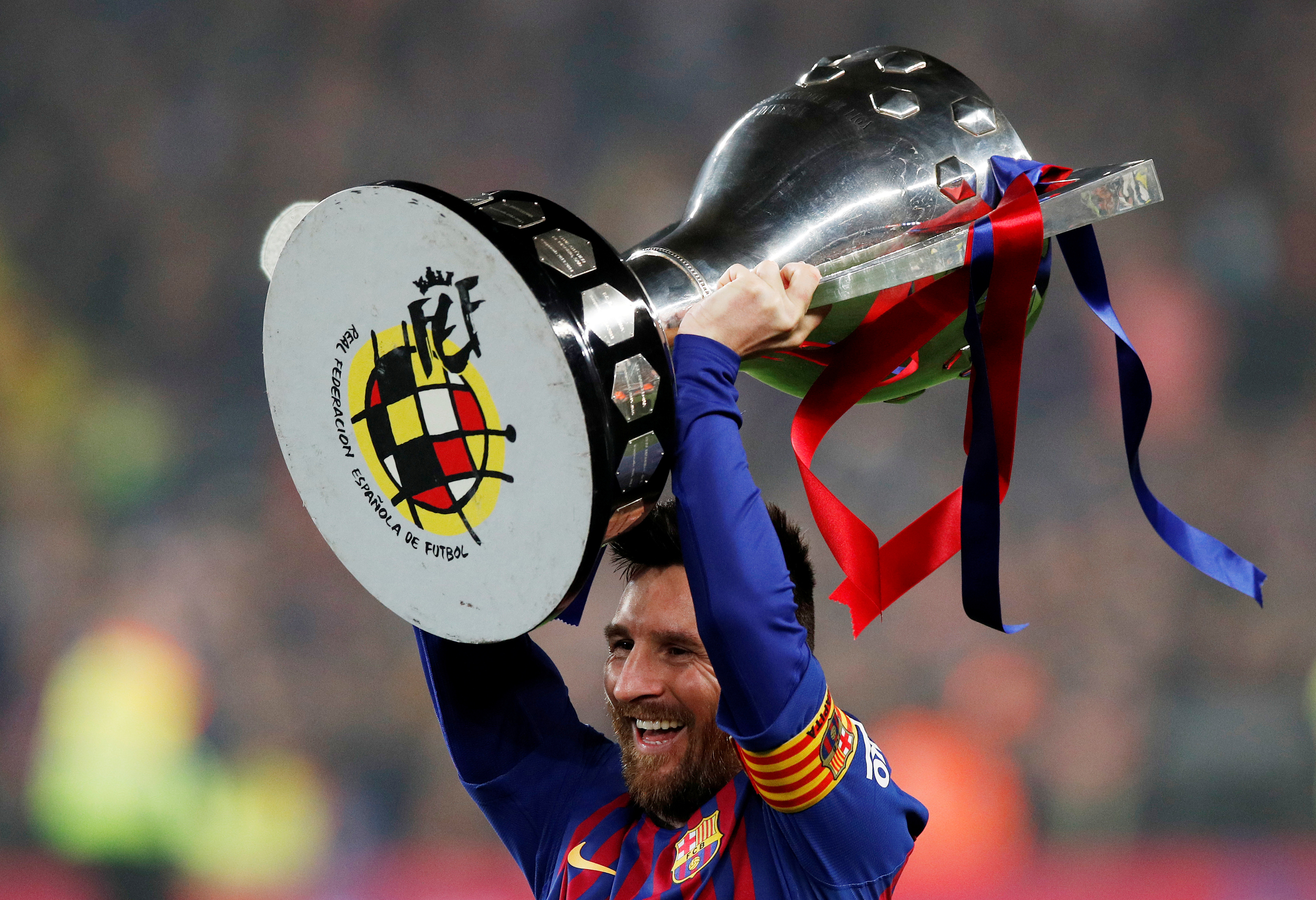 Barcelona's Lionel Messi celebrates winning La Liga with the trophy