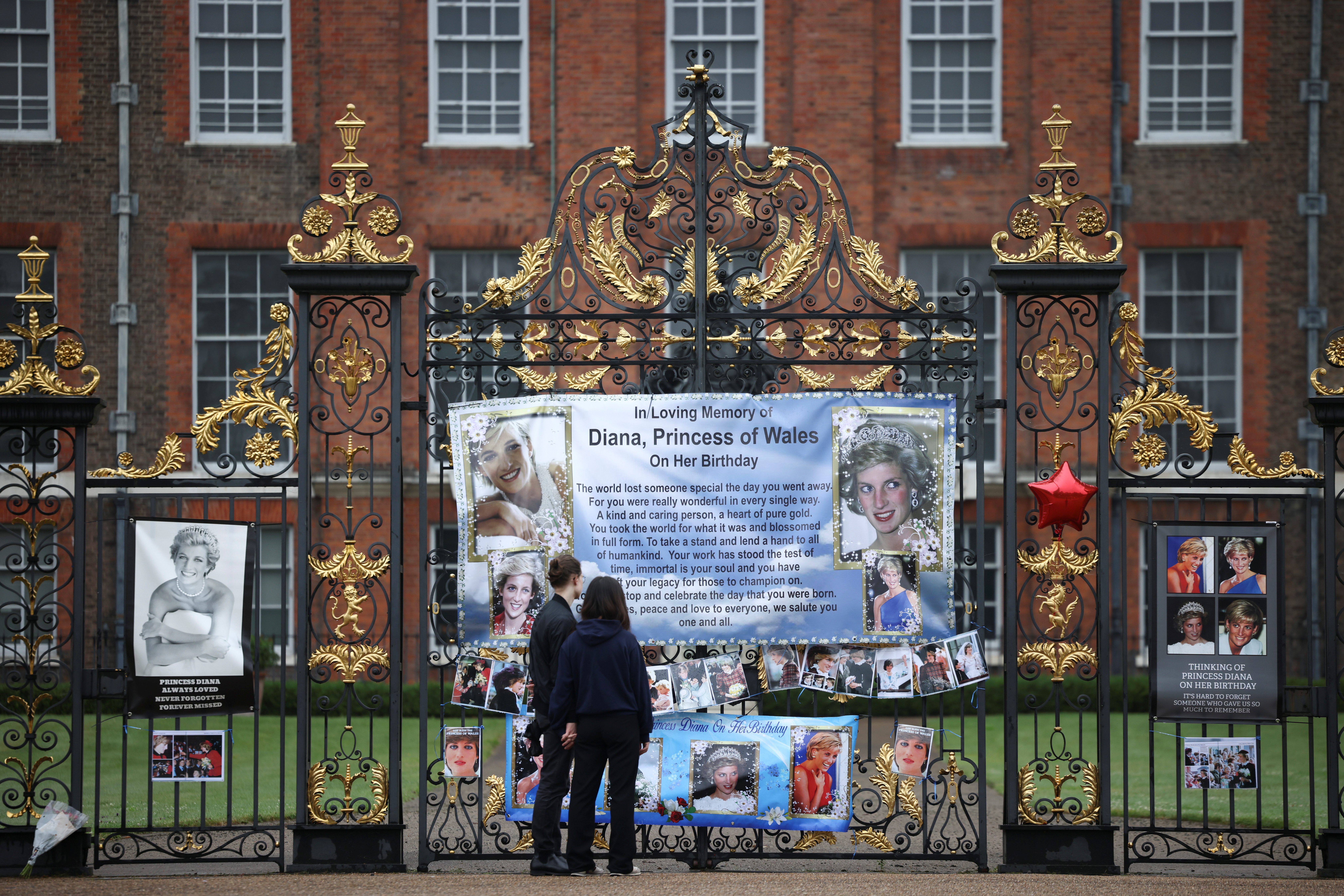 People look at tributes for Britain's Princess Diana, outside Kensington Palace in London