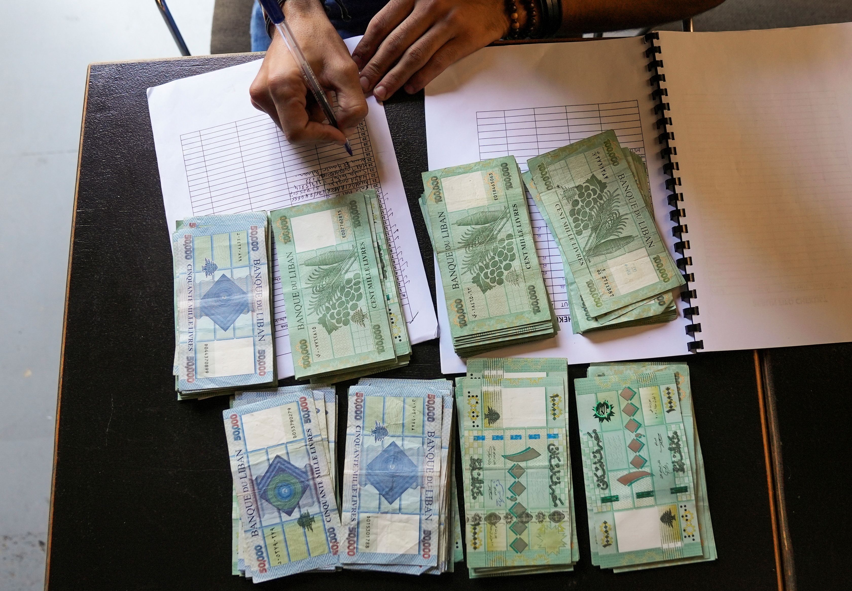 Lebanese pound banknotes are pictured on a desk in Beirut