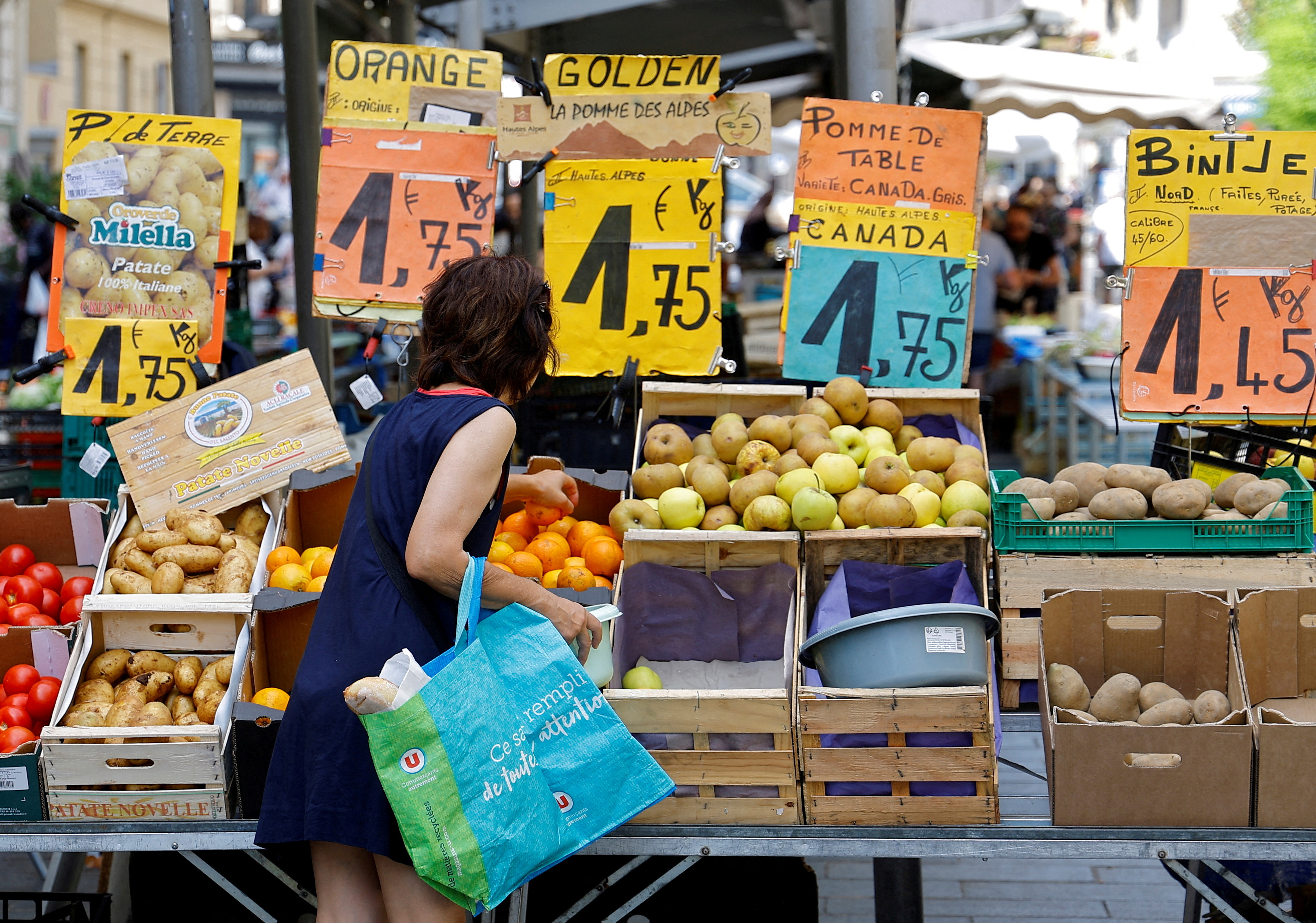 Price tags are seen as a woman shops at a local market in Nice
