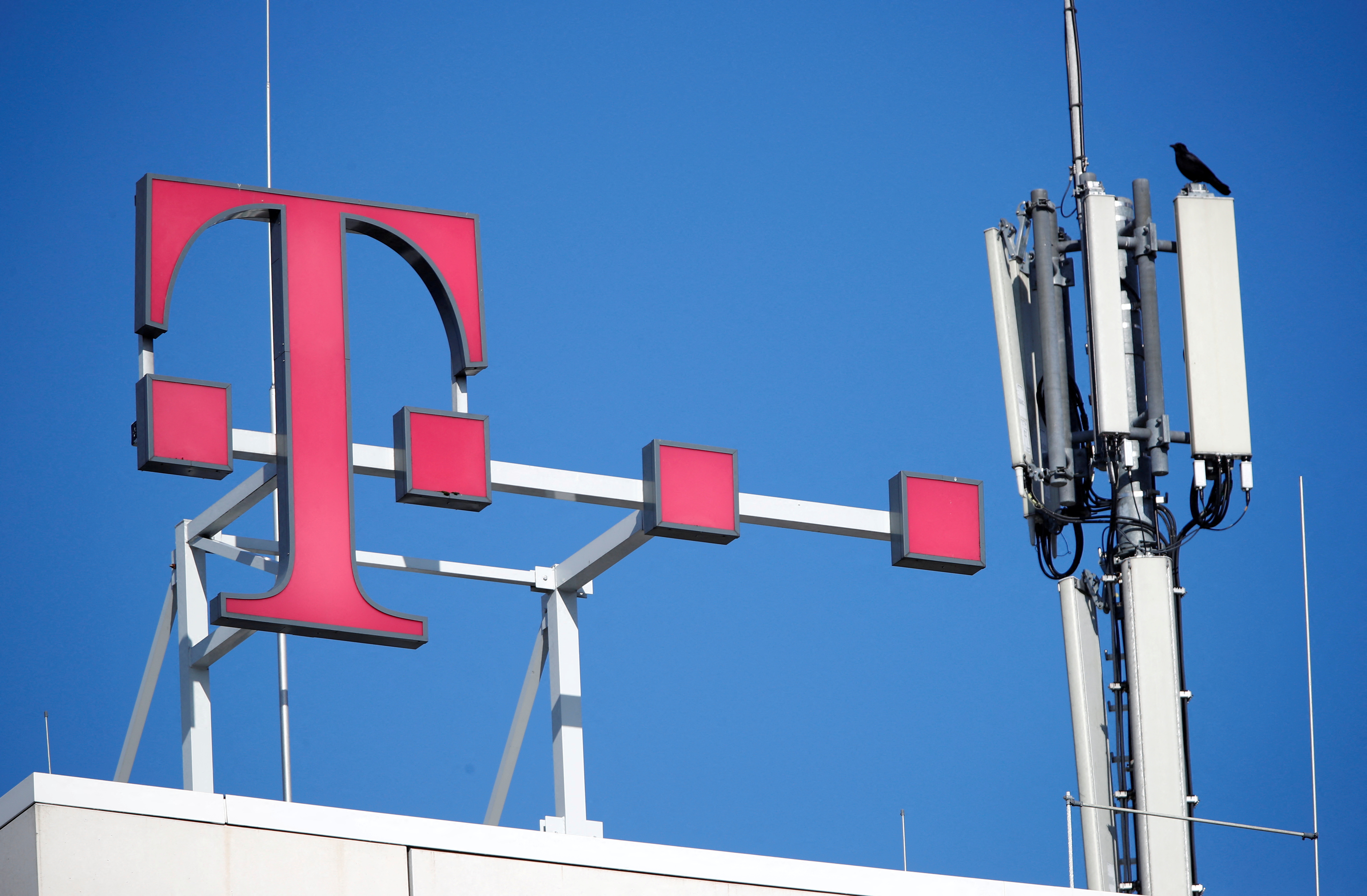 The logo of German telecoms giant Deutsche Telekom and GSM antennas are seen atop the company's headquarters in Bonn