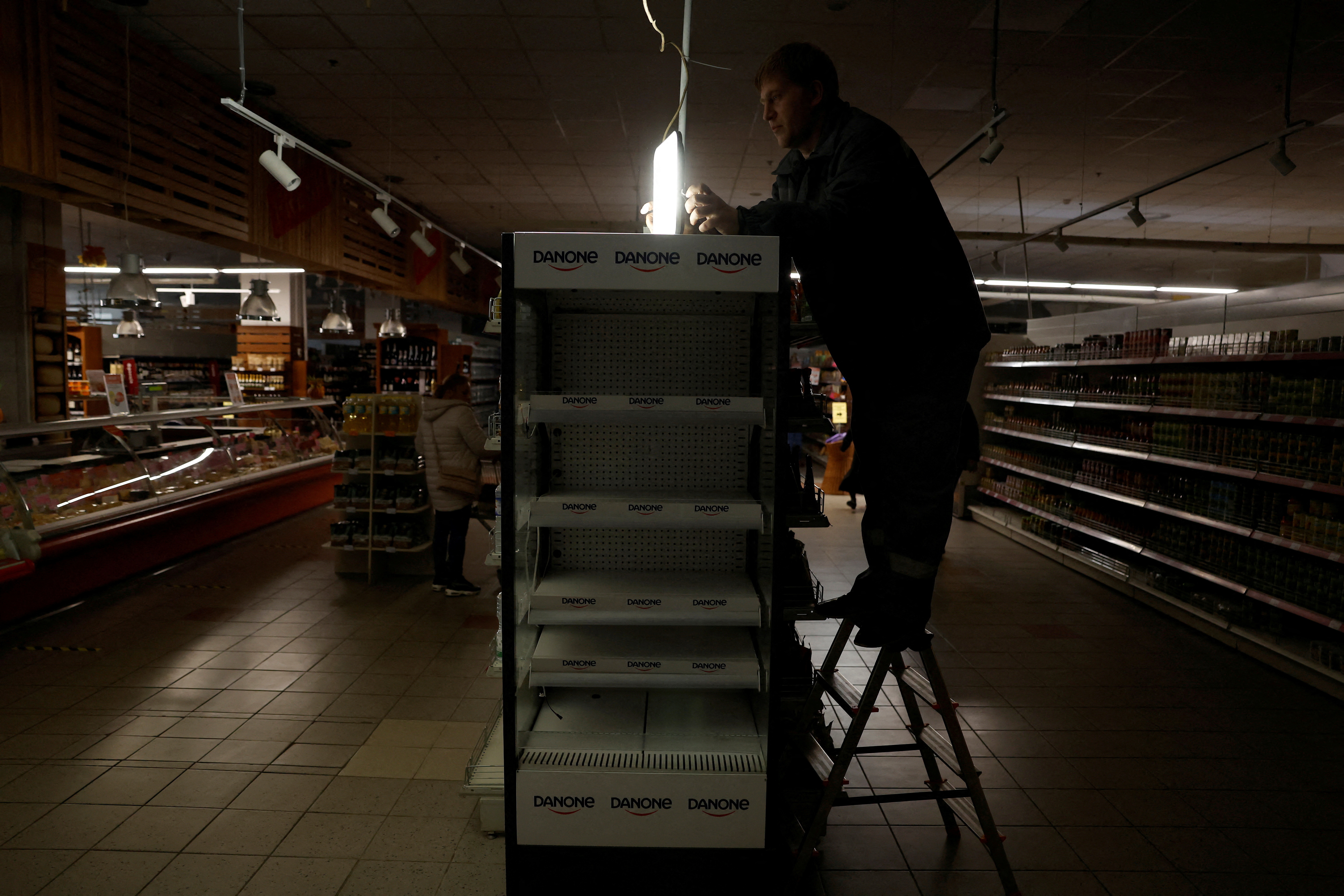 People shop during an electricity outage, in Kharkiv