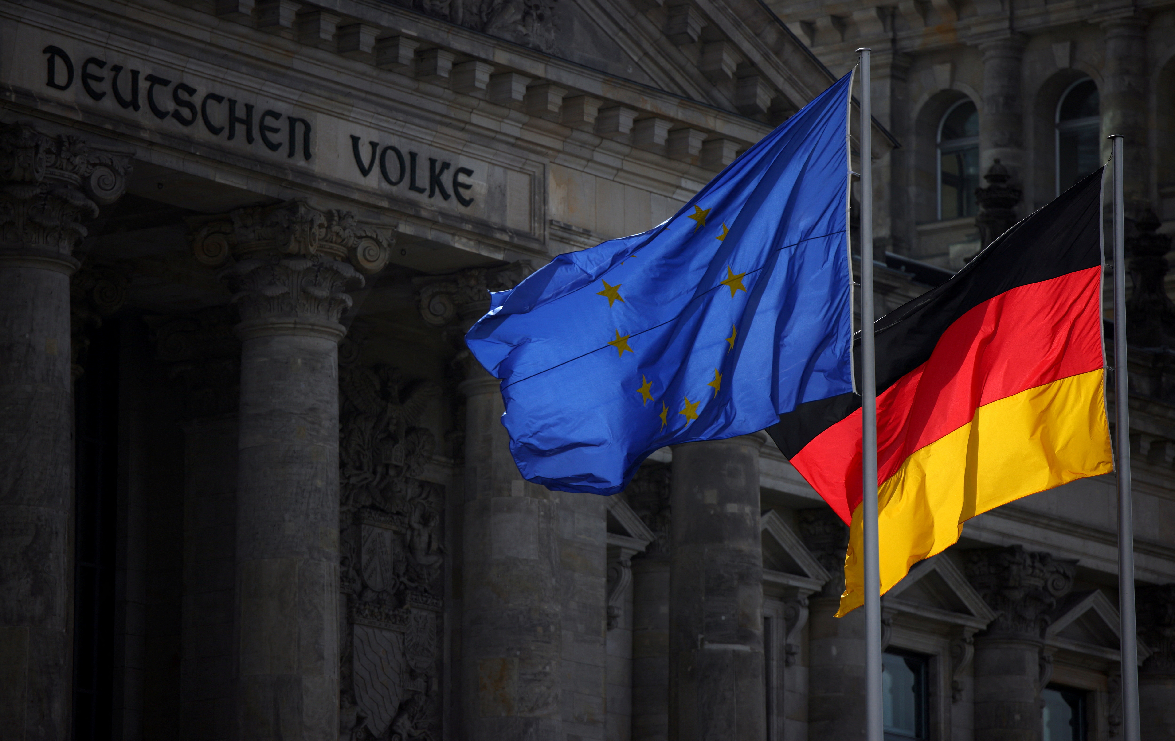 The flags of EU and Germany fly in front of Reichstag building in Berlin