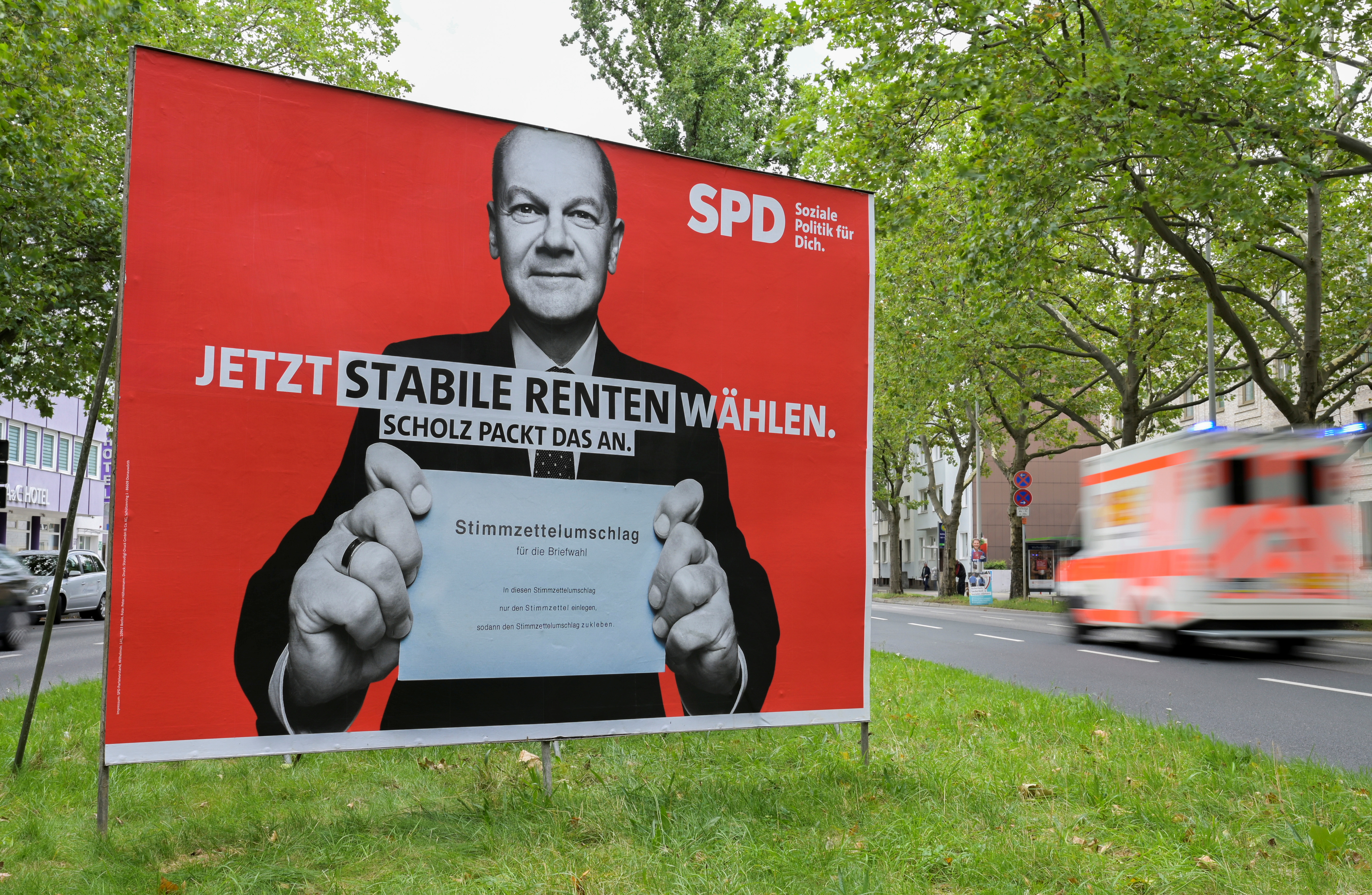 A car passes near an election poster showing Olaf Scholz, German Minister of Finance and top candidate of the The Social Democratic Party of Germany (SPD), who holds a letter for postal voting in Hanover, Germany August 17, 2021. REUTERS/Fabian Bimmer