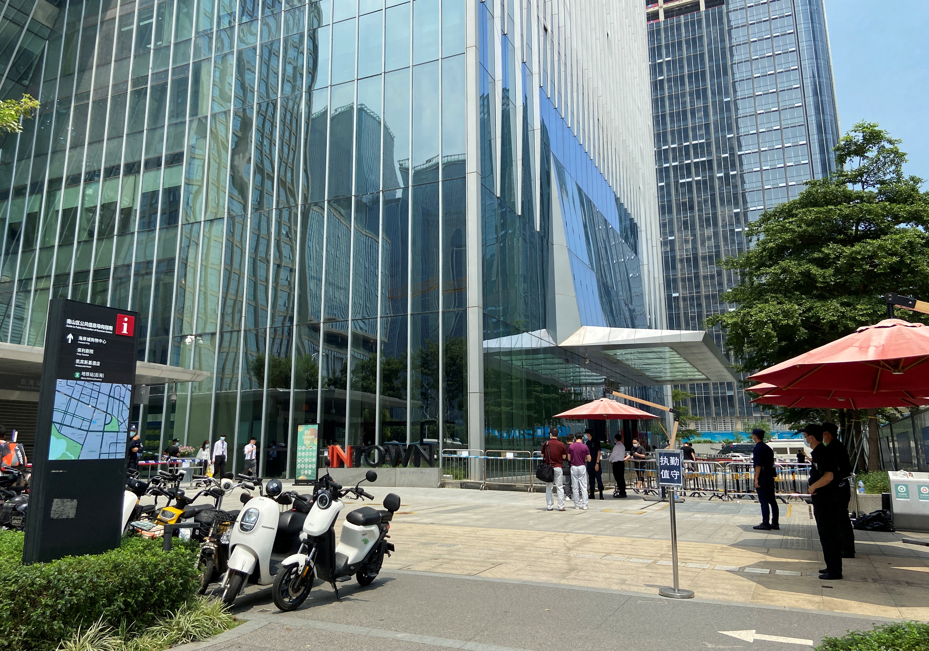 Security personnel stand guard outside Evergrande’s headquarters in Shenzhen