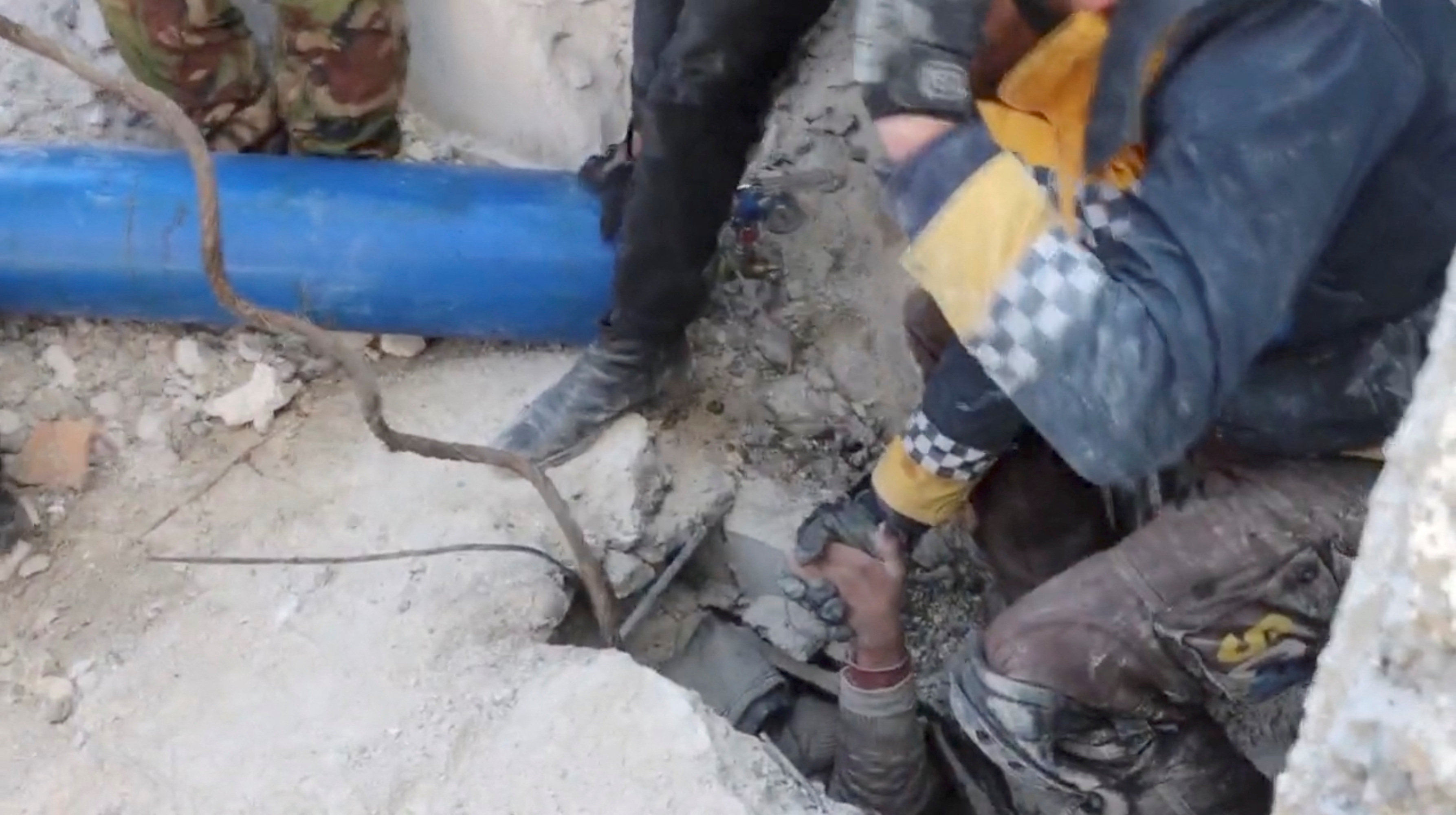 Rescuers pull out a child from under rubble, in Jandaris