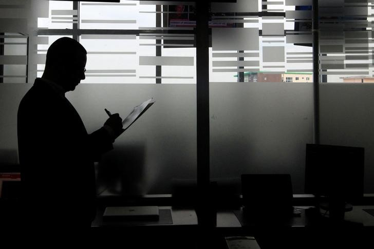 Luis Carlos Rodriguez, an account executive of the stock exchange, checks a document in the Invercasa building in Managua