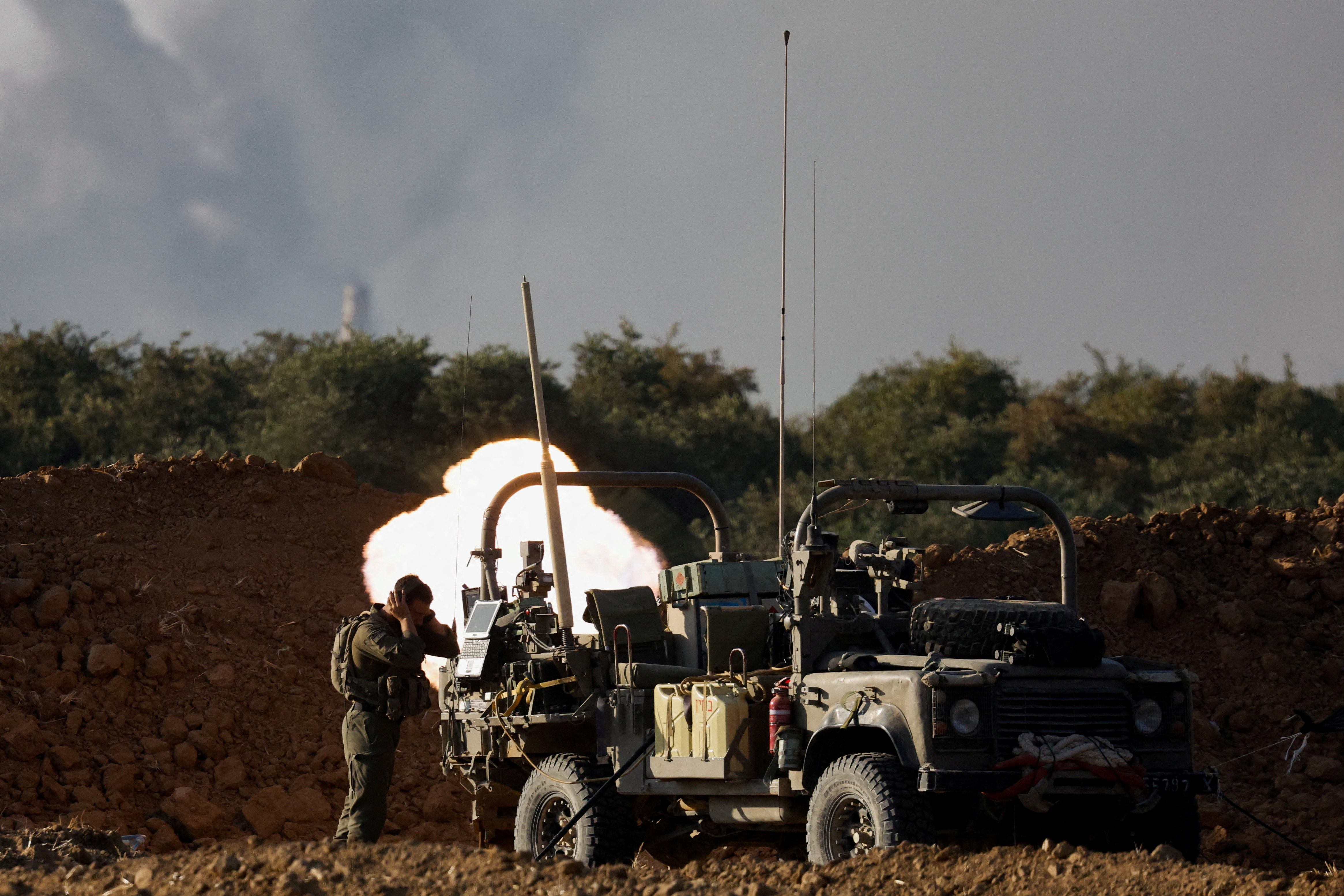 Israeli soldiers fire a mortar, amid the Israel-Hamas conflict, near the Israel-Gaza border