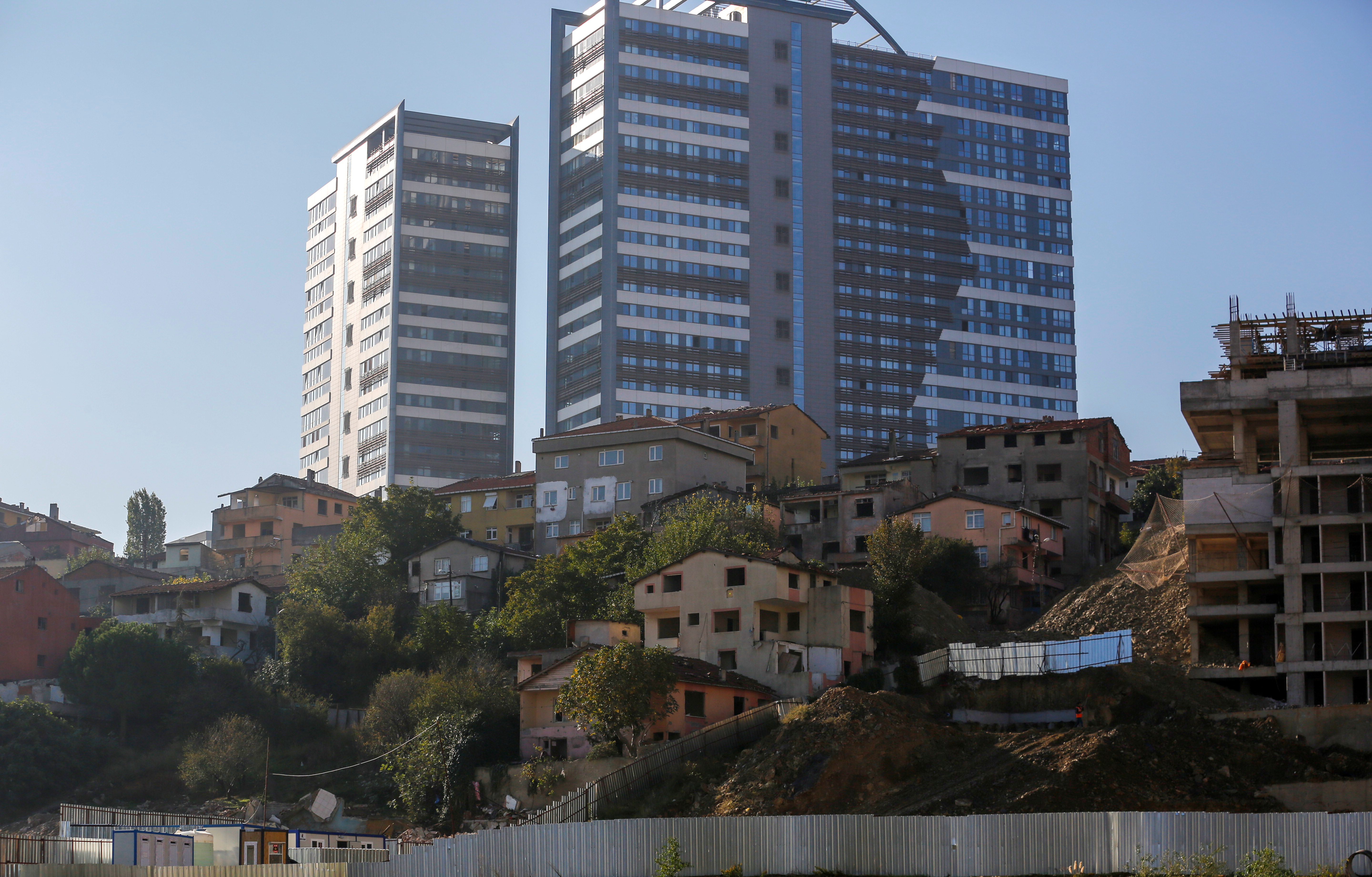 Abandoned houses are seen in front of brand new residential buildings at an urban transformation project area in Istanbul