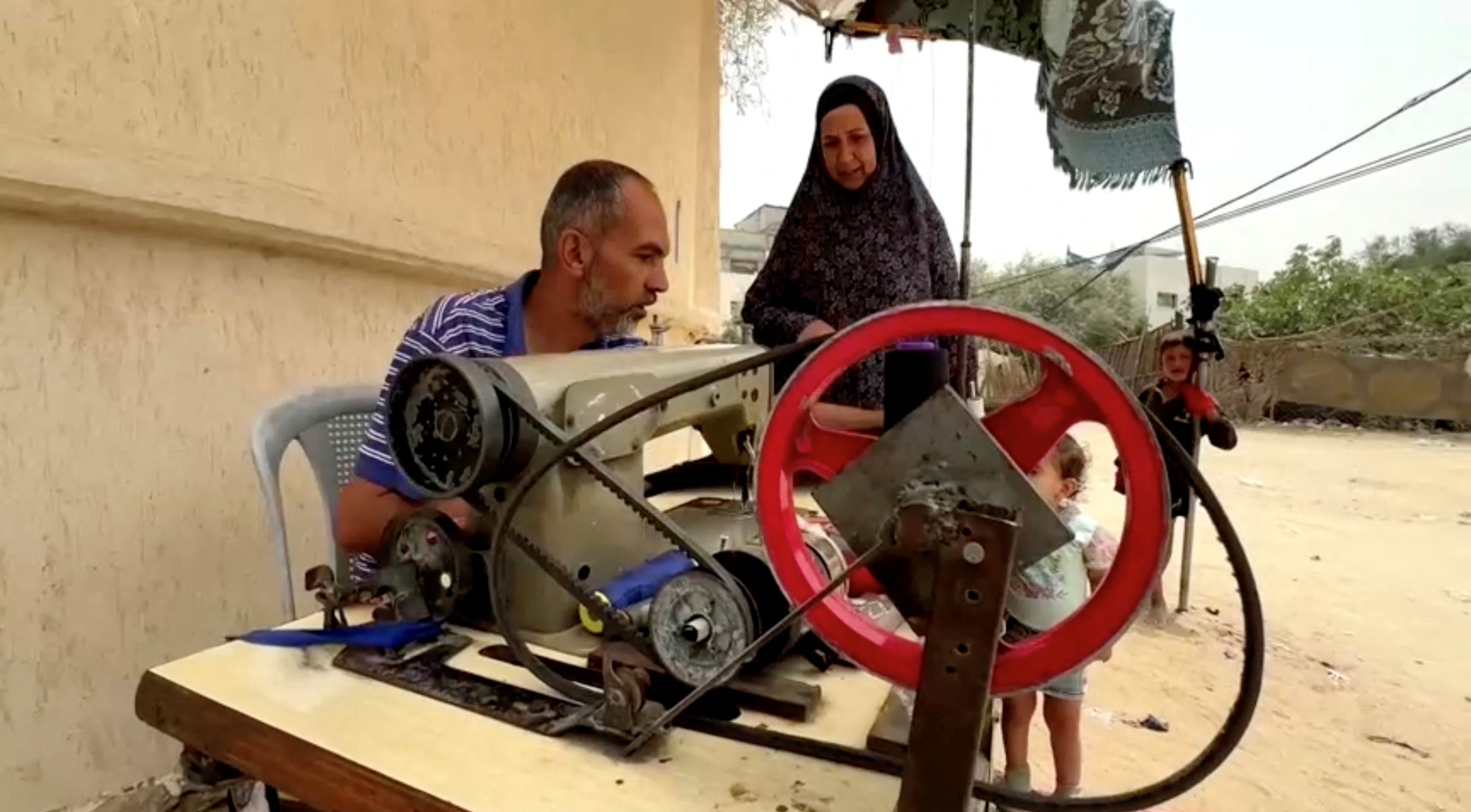 Palestinian tailor Anwar Abu Keresh alters clothes due to food scarcity, in Deir Al-Balah