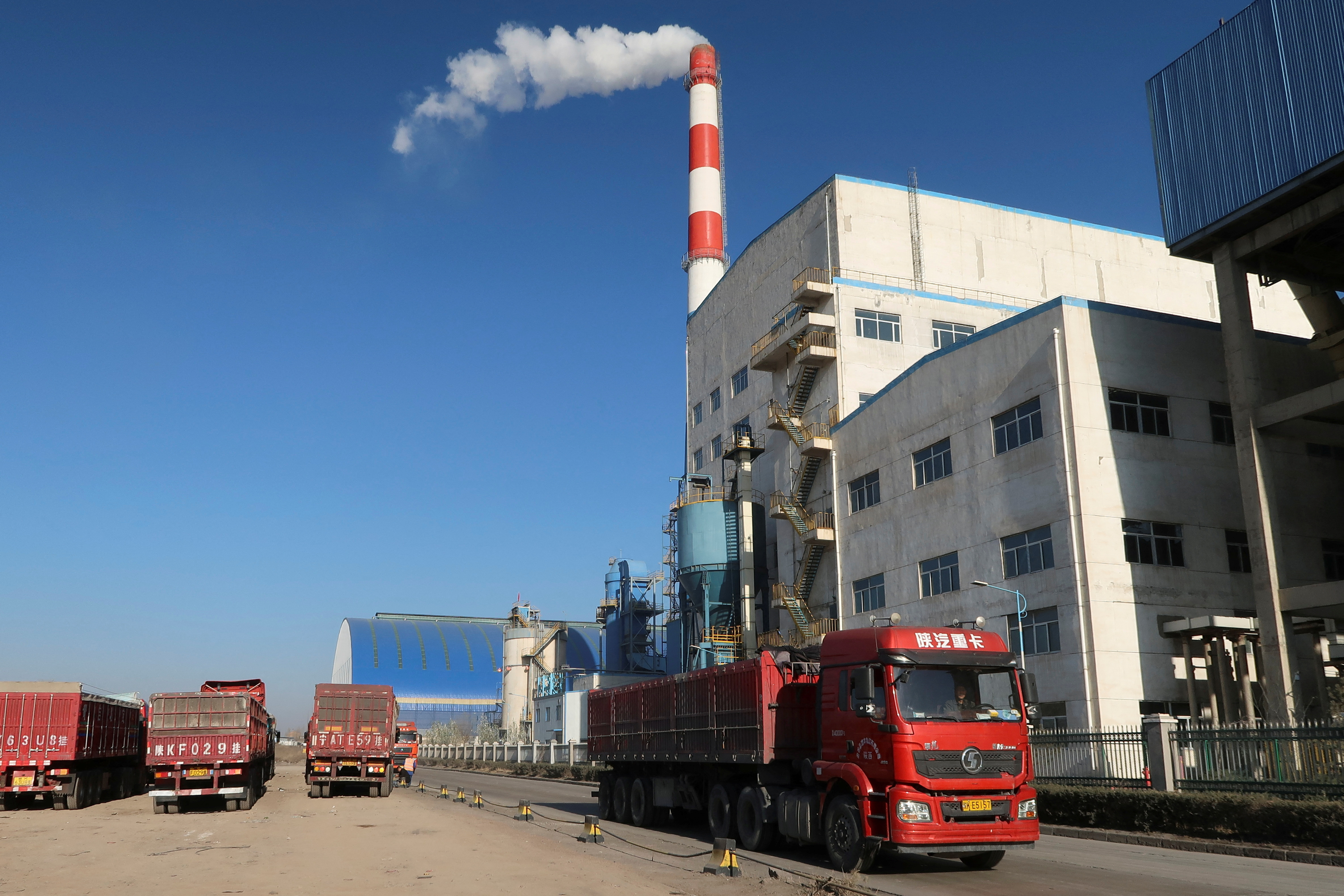 Truck passes by a chemical factory near the Jinjie Industrial Park in Shenmu