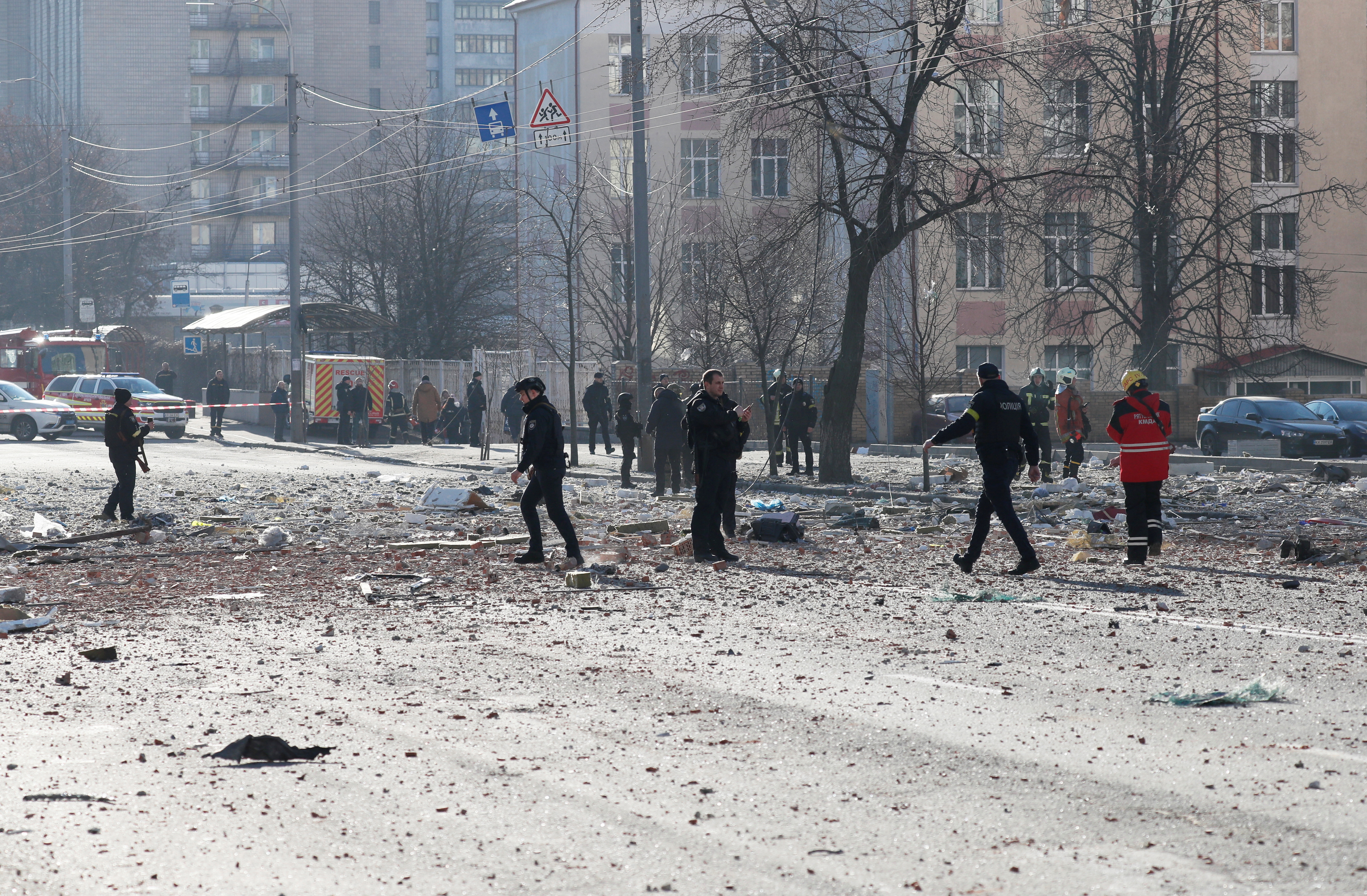 Police and members of emergency services work near an apartment building damaged by recent shelling in Kyiv, Ukraine February 26, 2022. REUTERS/Gleb Garanich