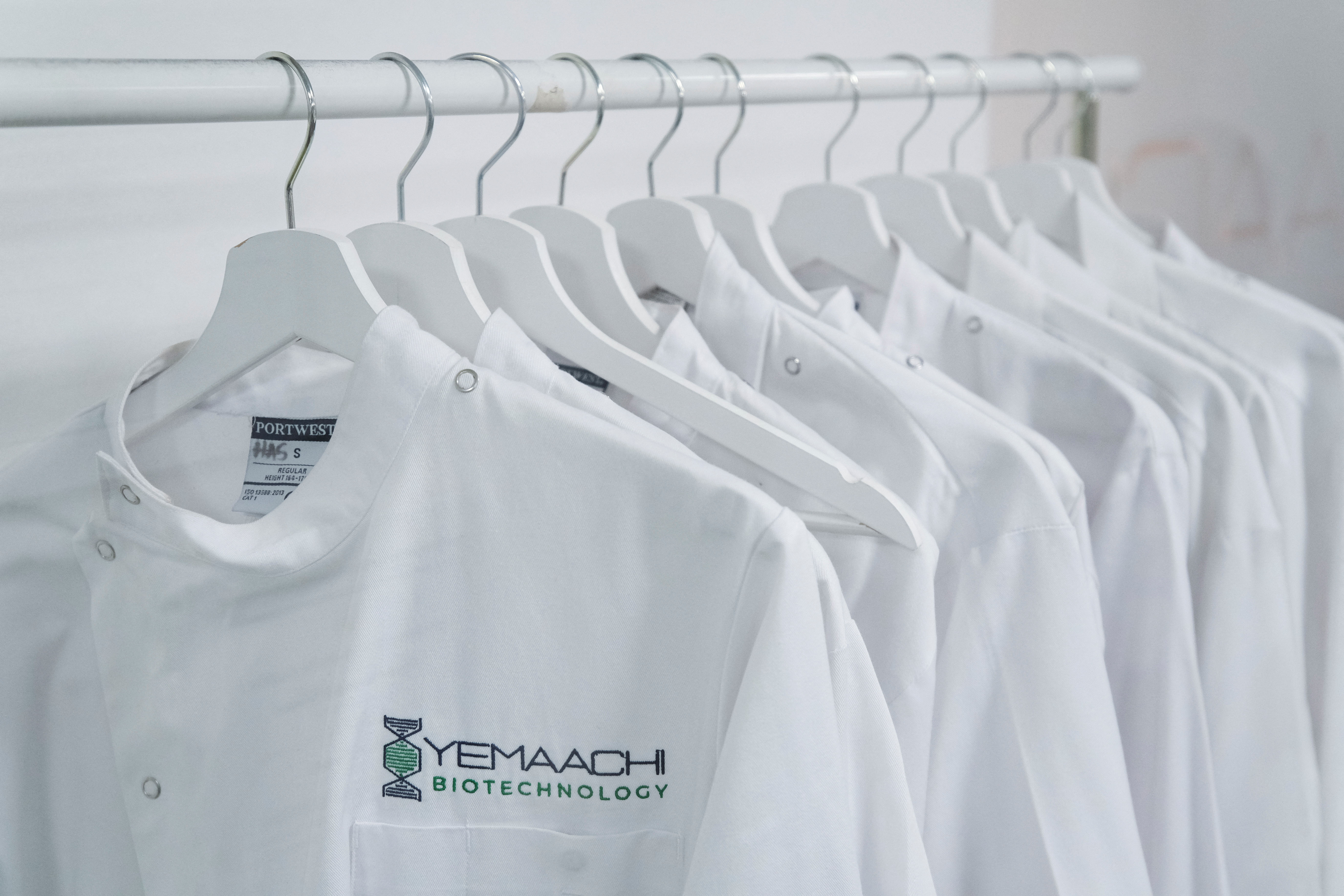 Staff lab coats hang on a rack at Yemaachi Biotechnology, a cancer research laboratory in Accra