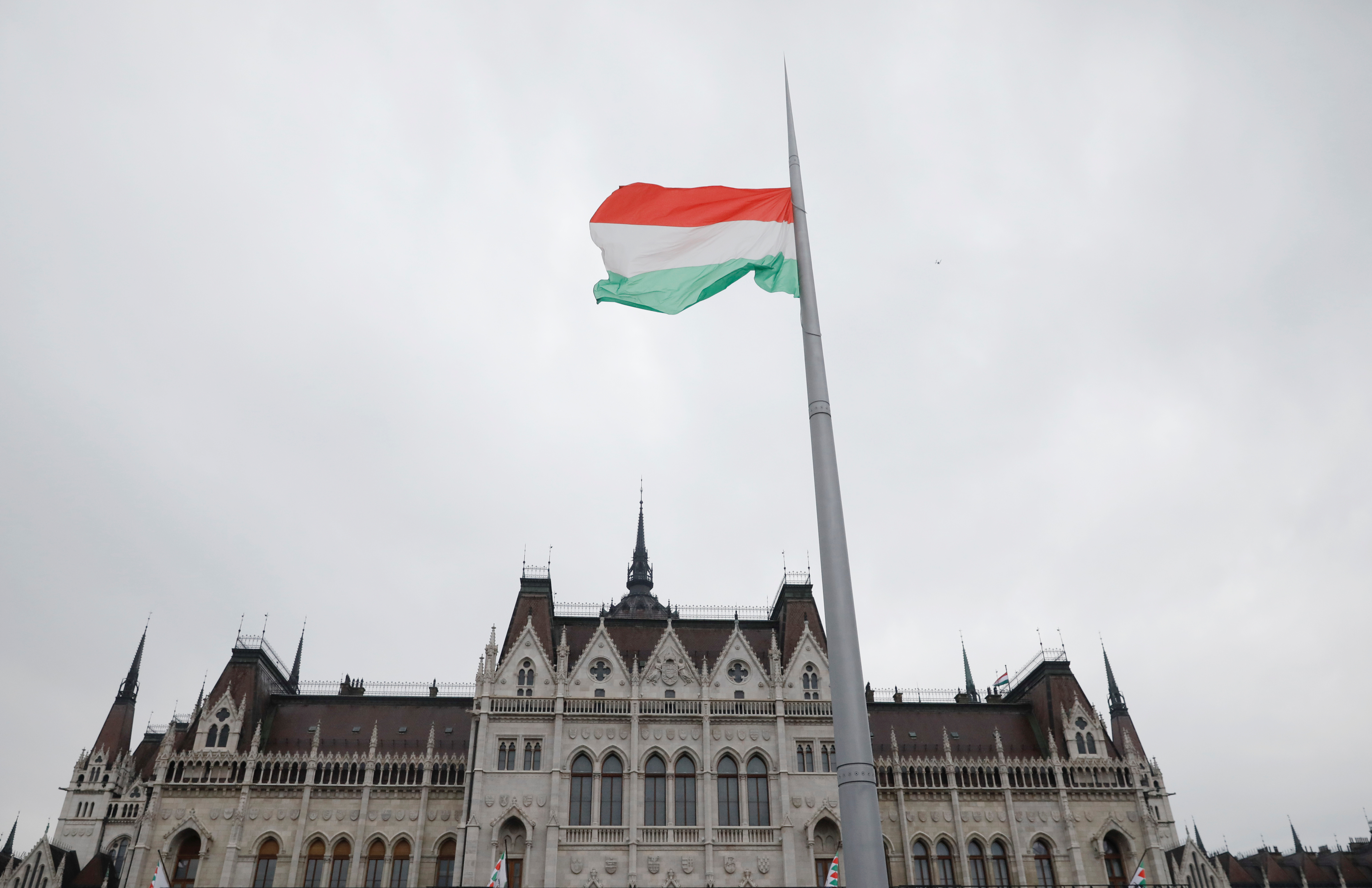 A Hungarian national flag flutters outside the Hungarian parliament building at a pro-Orban rally during Hungary's National Day celebrations in Budapest