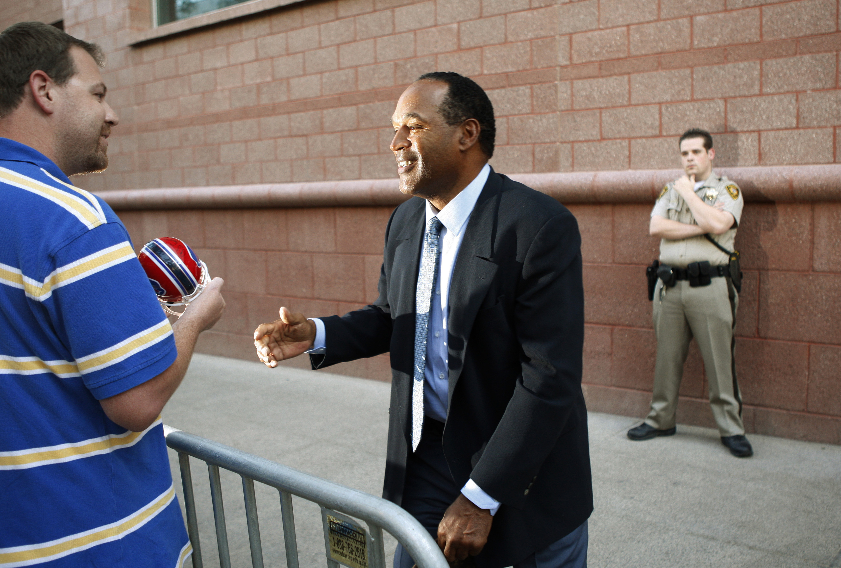 O.J. Simpson signs an autograph as he leaves the Clark County Regional Justice Center in Las Vegas