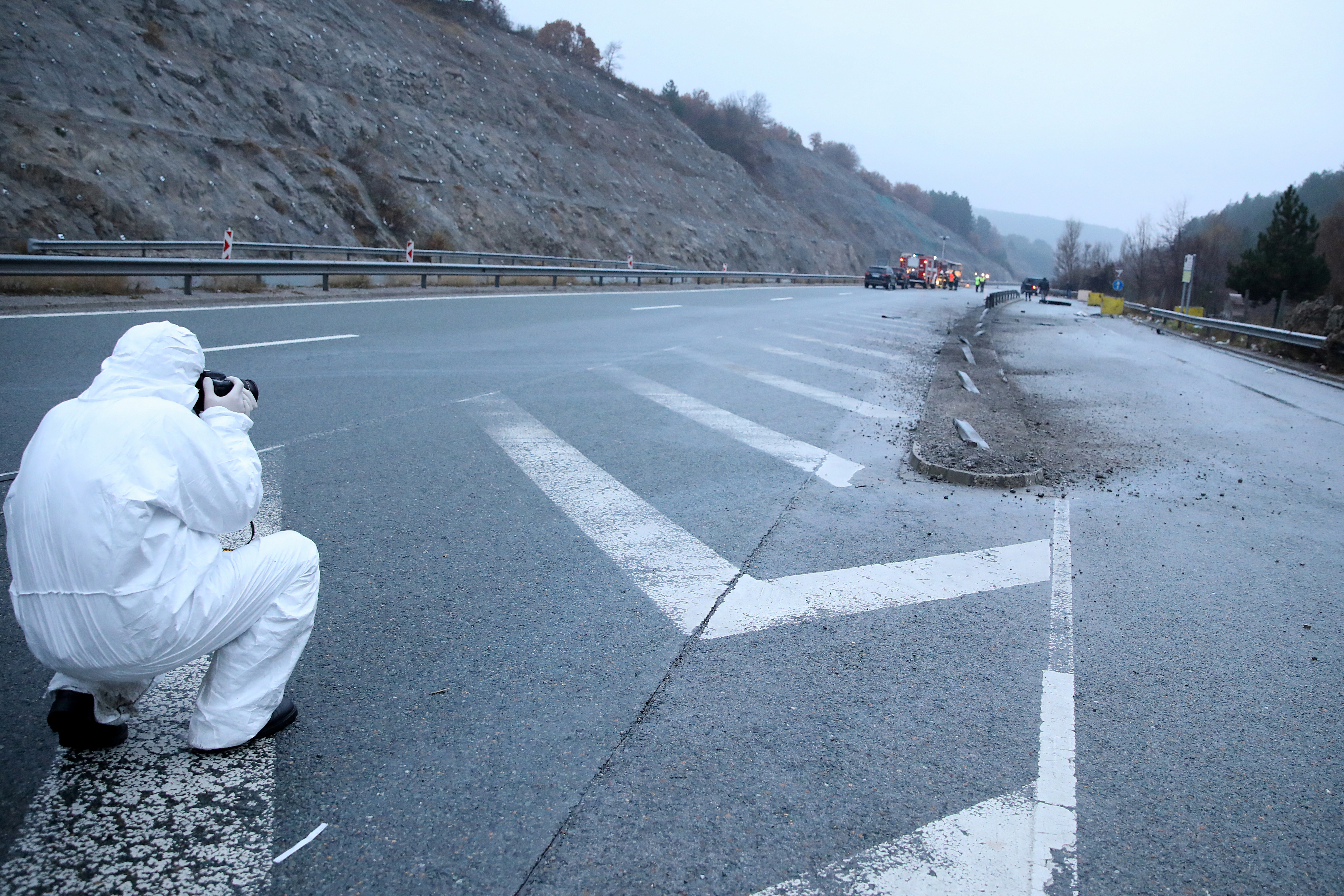 A member of forensic police works near the site where a bus with North Macedonian plates caught fire on a highway, near the village of Bosnek, Bulgaria, November 23, 2021. REUTERS/Stoyan Nenov