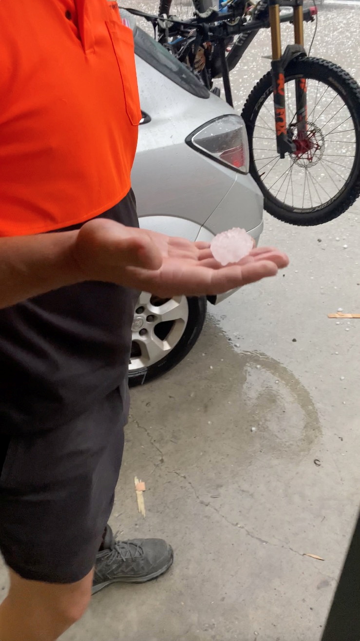 A person holds a hailstone in a garage in Gold Coast, Queensland, Australia October 19, 2021, in this still image obtained from video. Courtesy of Greg Hateley / Social Media via REUTERS  