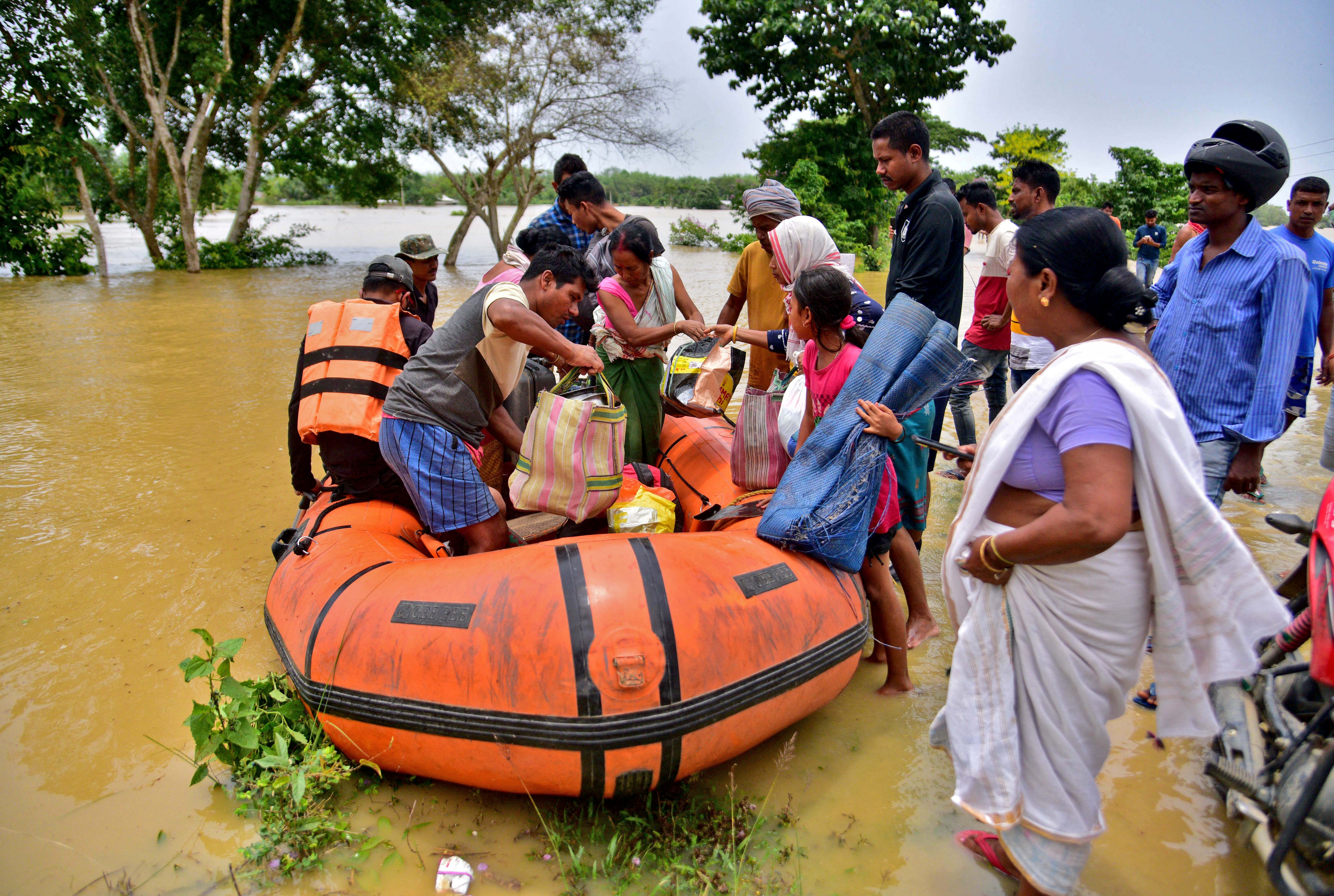 People disembark a boat after they were evacuated from a flooded village in Nagaon district
