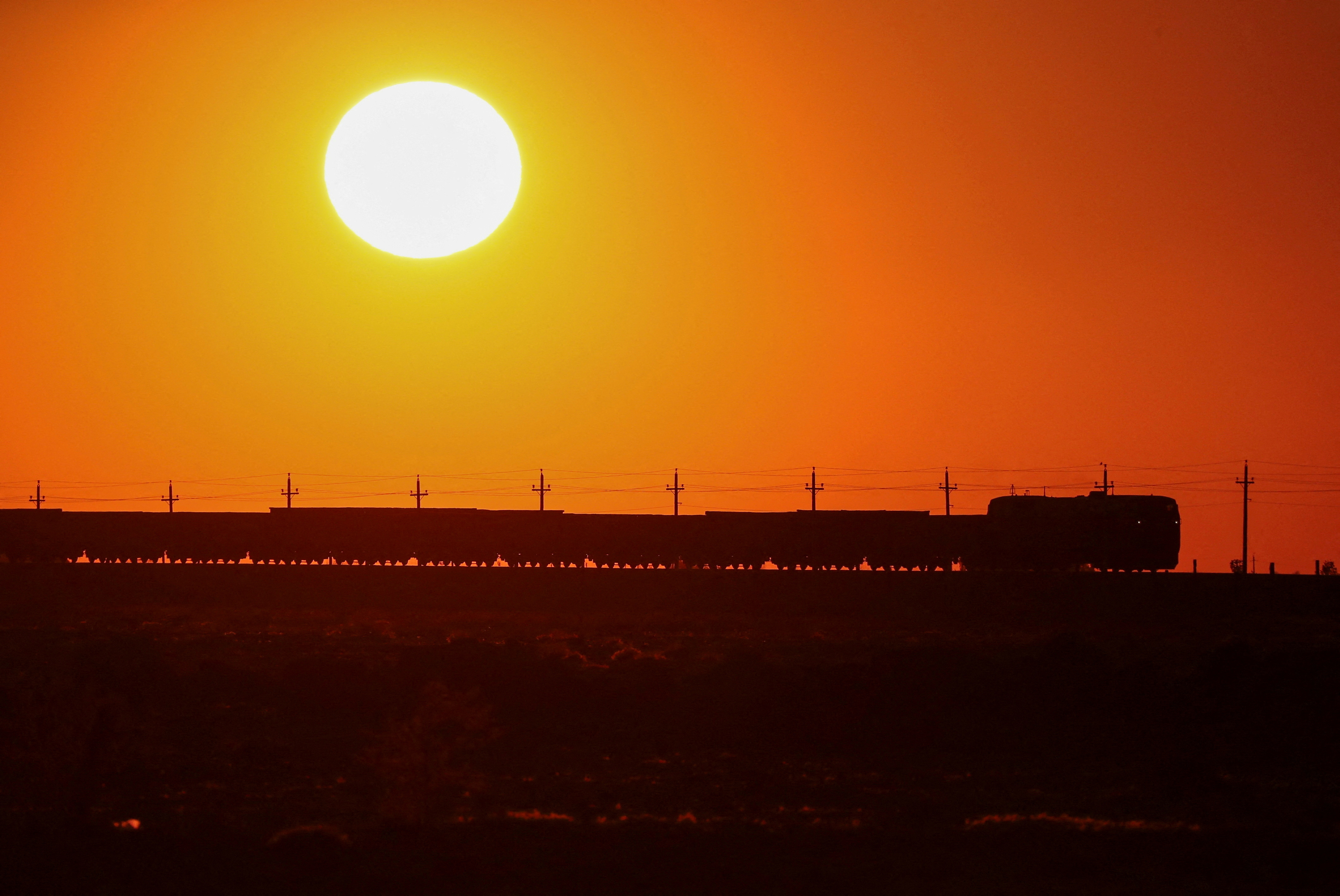 A freight train moves during sunset in the Almaty region