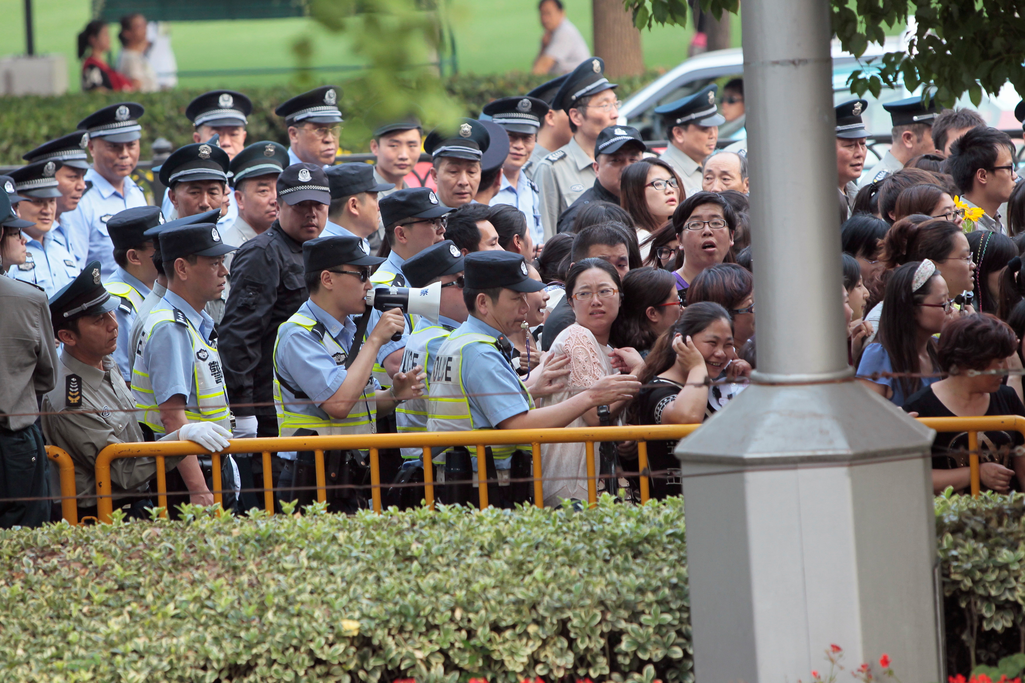 Police officers remove fans standing outside the opening ceremony of the 17th Shanghai International Film Festival
