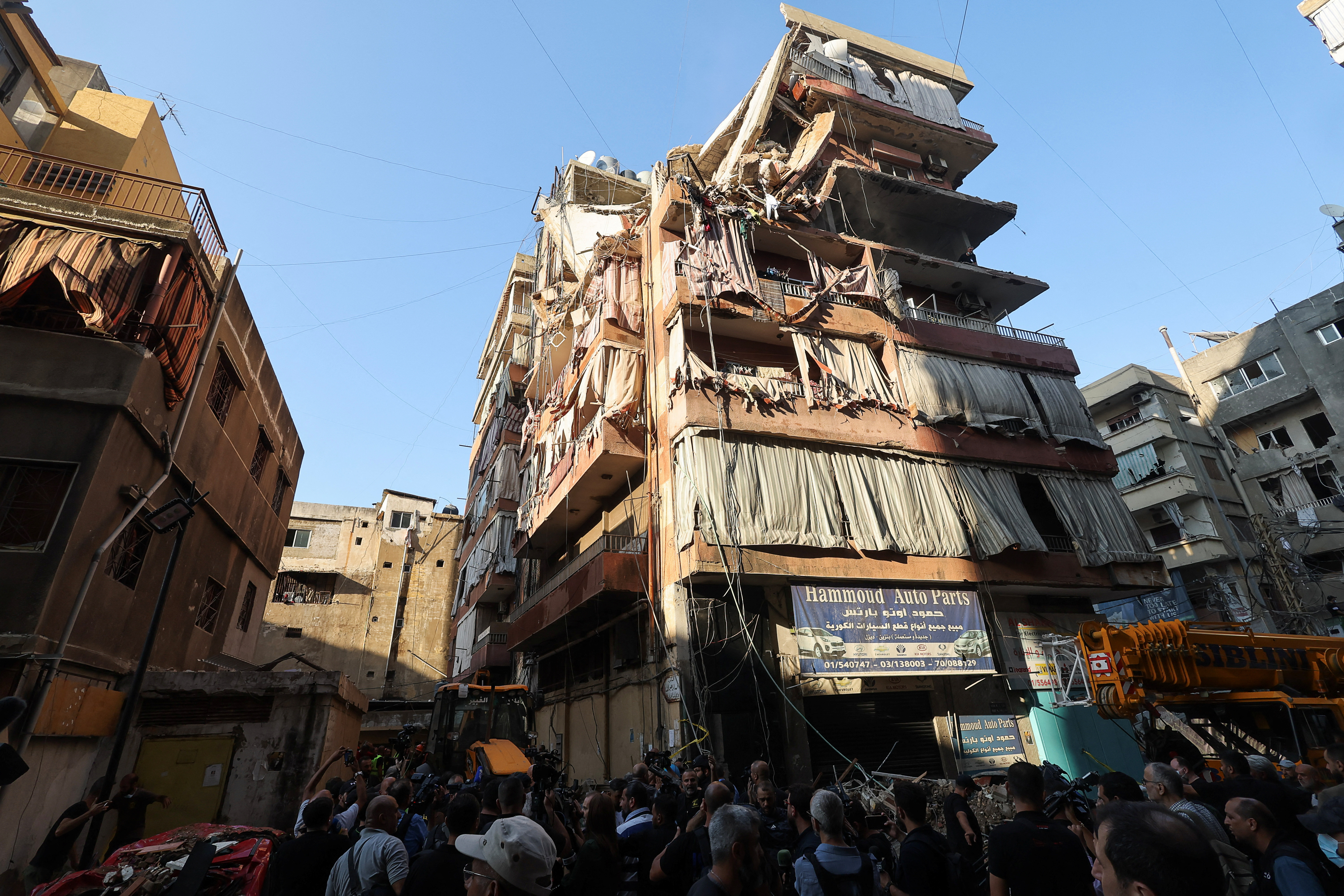 People gather at the site of an Israeli strike in Beirut's southern suburbs