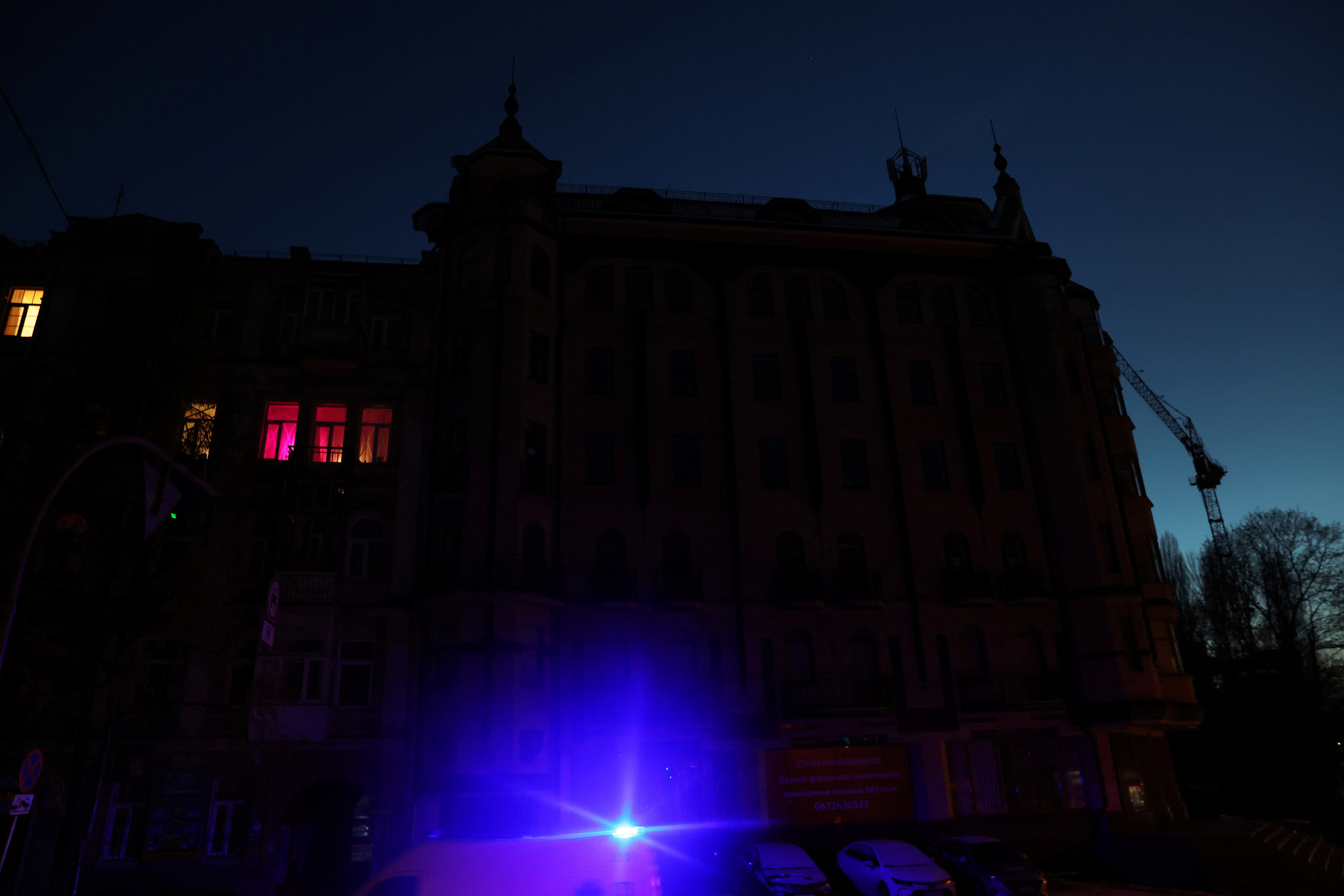 An ambulance drives by a building during power outages in Kyiv