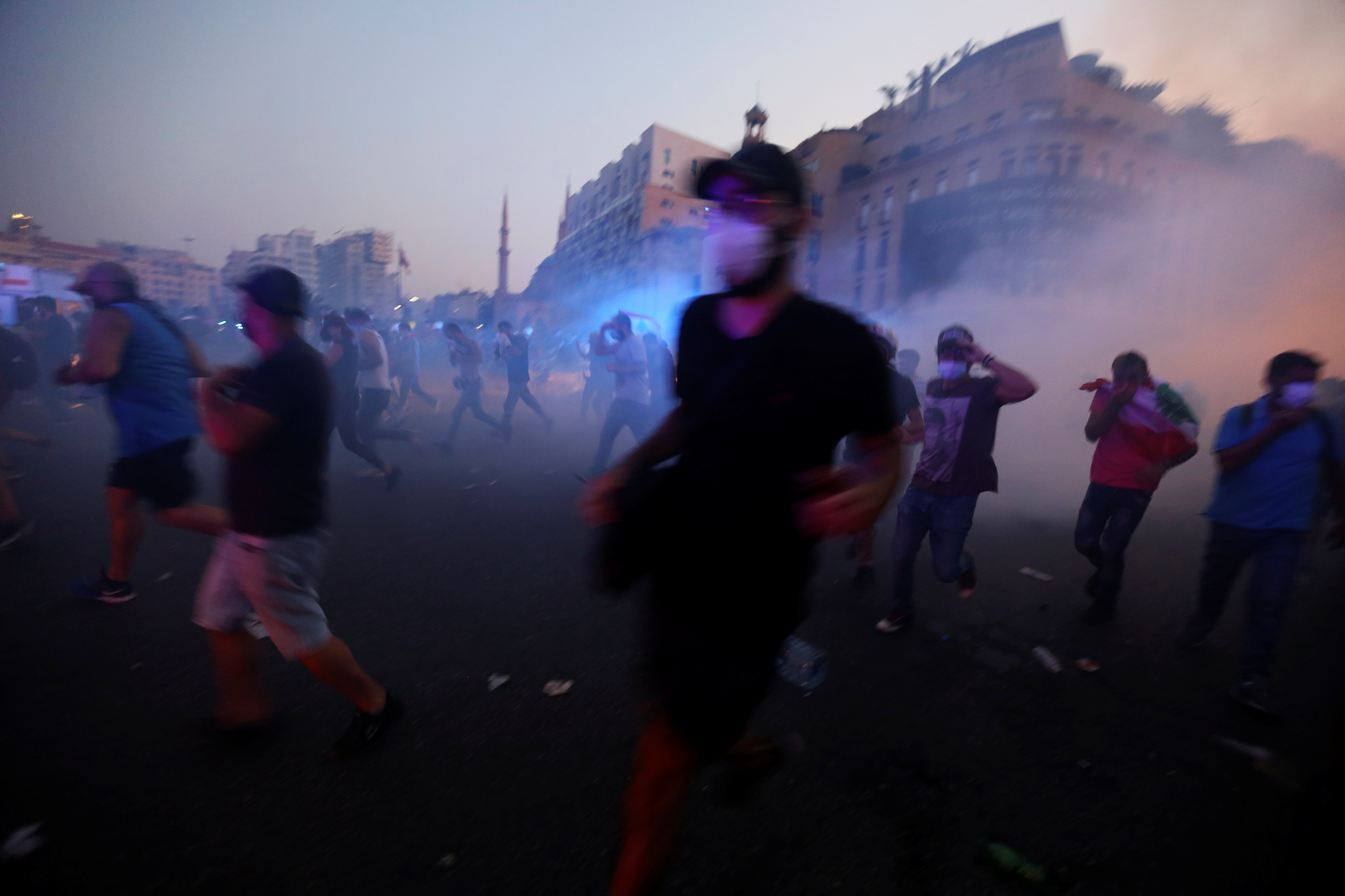 Demonstrators run during clashes with security forces during a protest near parliament in Beirut