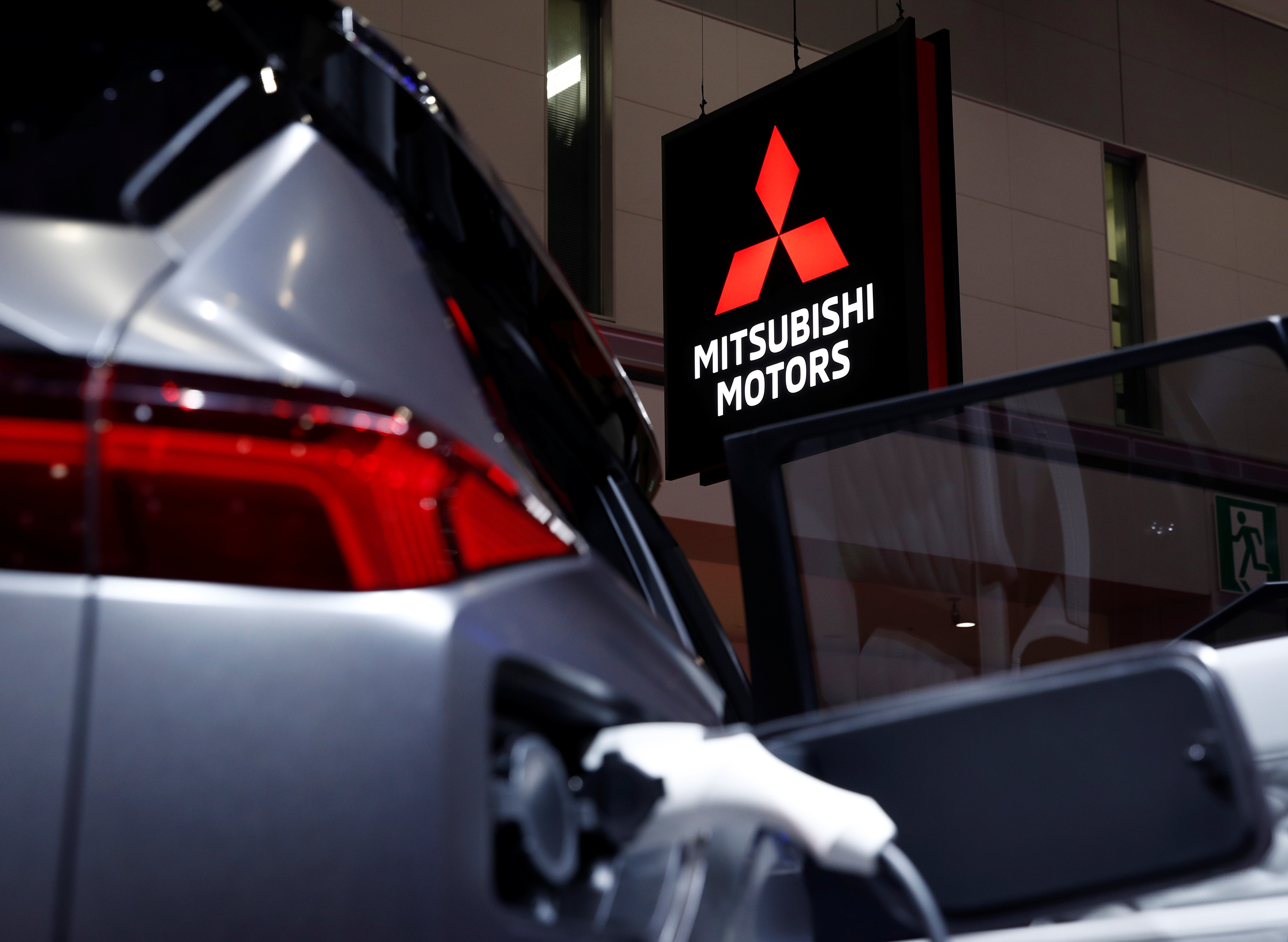 A Mitsubishi Motors signage is pictured next to a Mitsubishi electric car at the Tokyo Motor Show