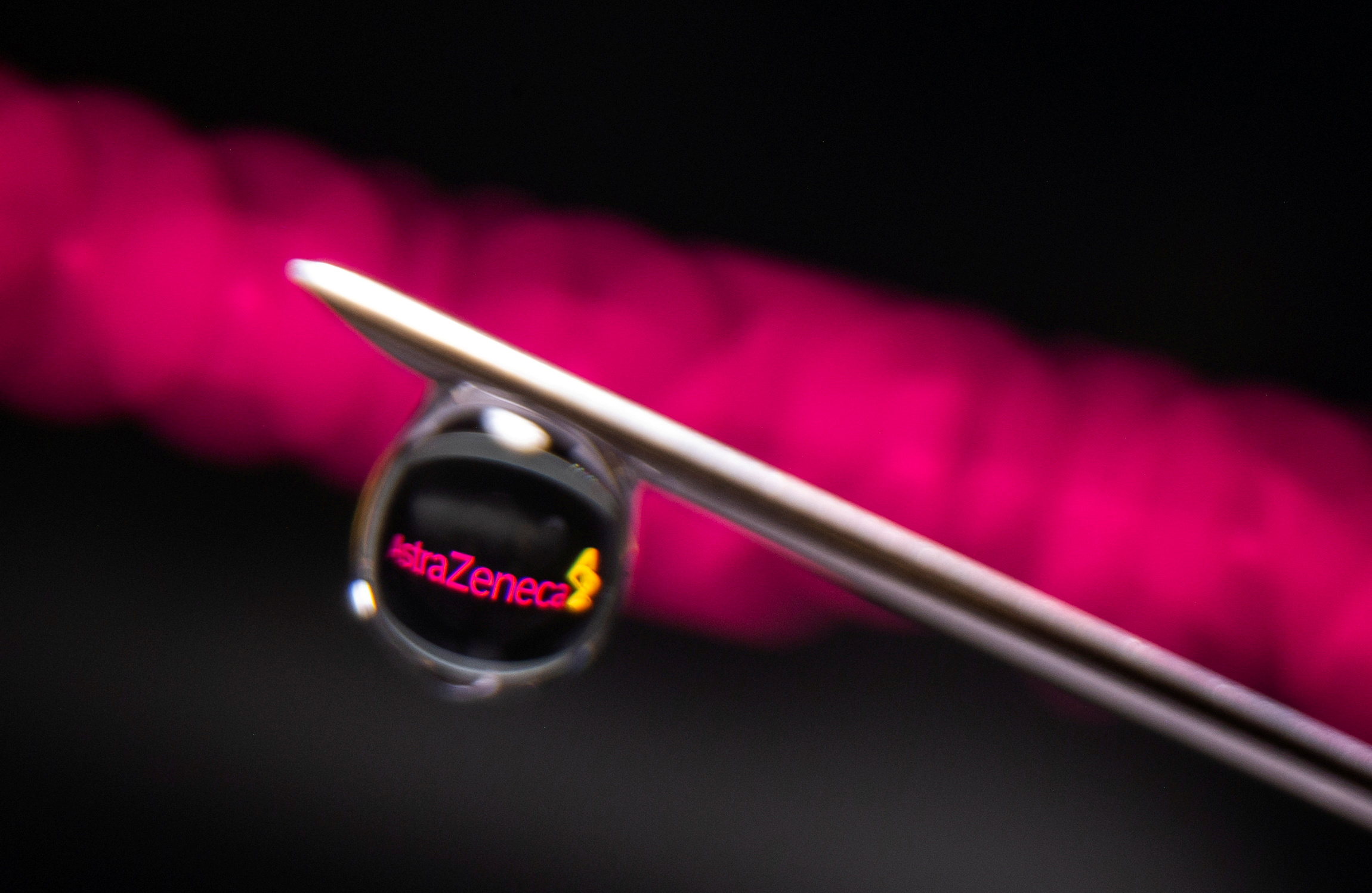 AstraZeneca logo is reflected in a drop on a syringe needle in this illustration photo