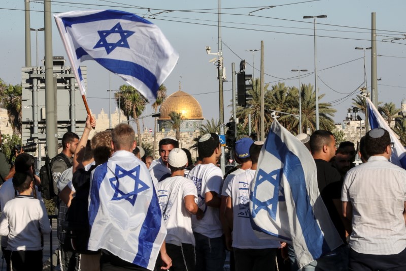 Israelis walk with flags outside Jerusalem's Old City