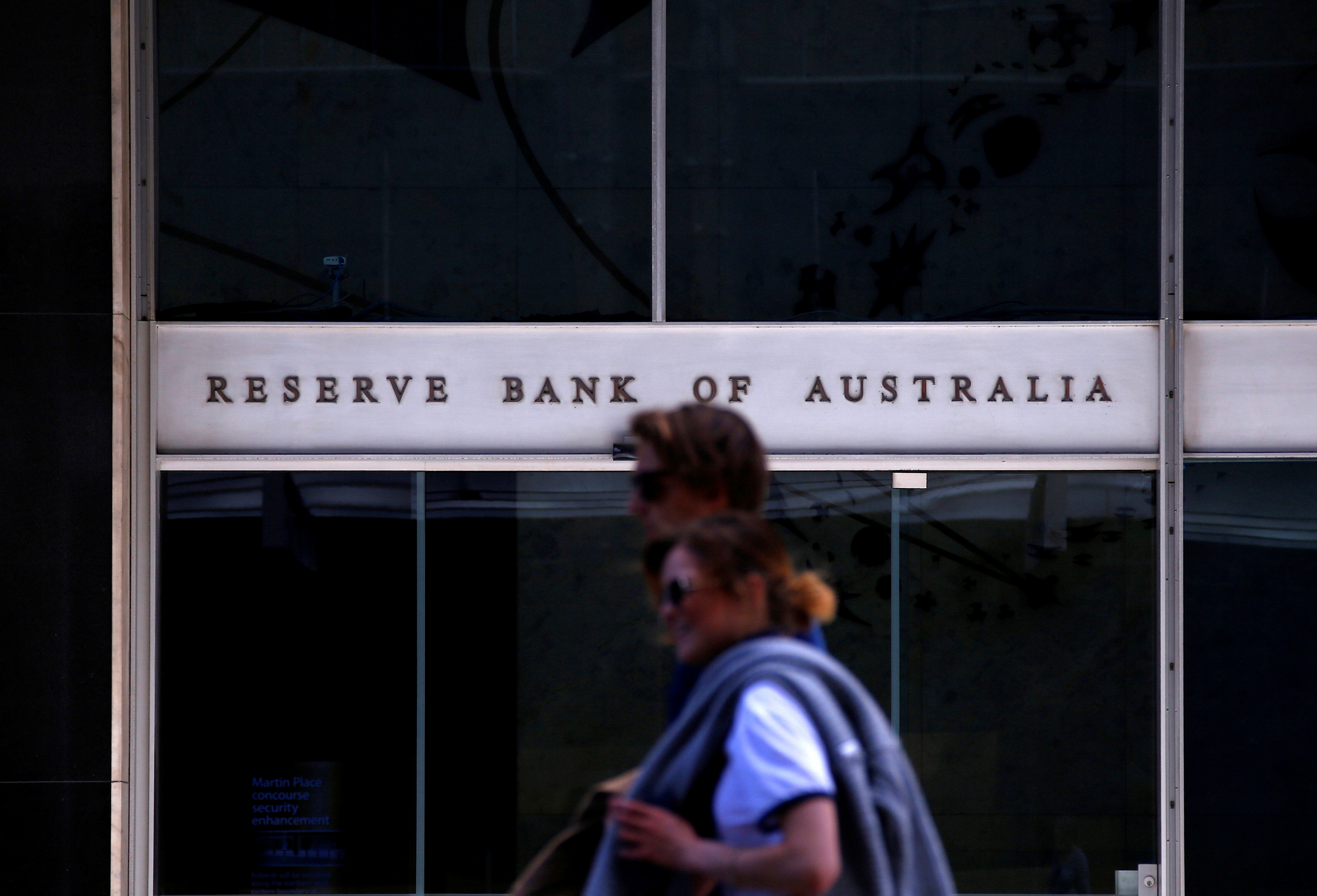 Pedestrians walk past the main entrance to the Reserve Bank of Australia building in central Sydney, Australia