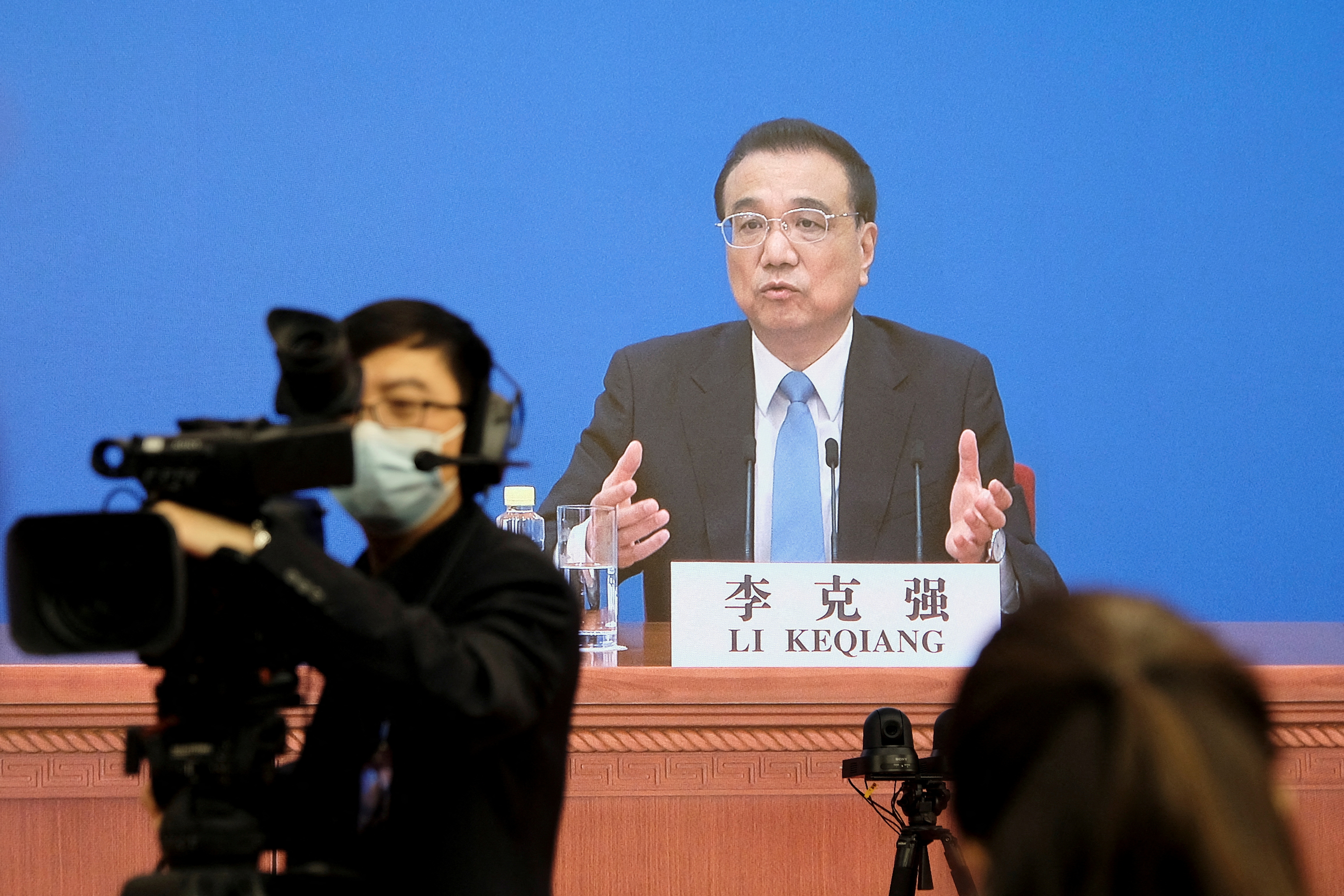 Chinese Premier Li Keqiang attends a news conference via video link in Beijing