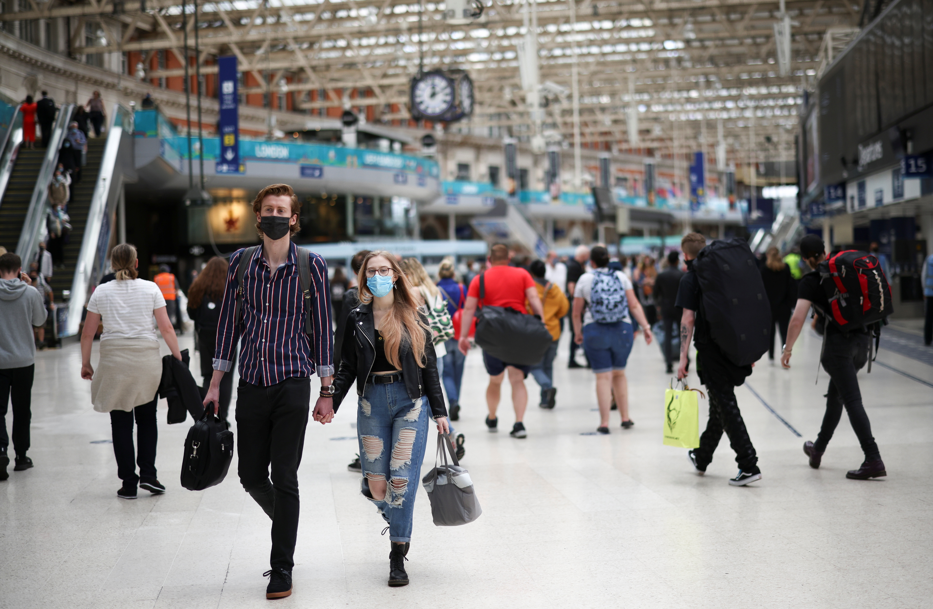 Des gens, certains portant des masques protecteurs, traversent la gare de Waterloo, au milieu de la pandémie de maladie à coronavirus (COVID-19), à Londres, Grande-Bretagne, le 4 juillet 2021. REUTERS/Henry Nicholls